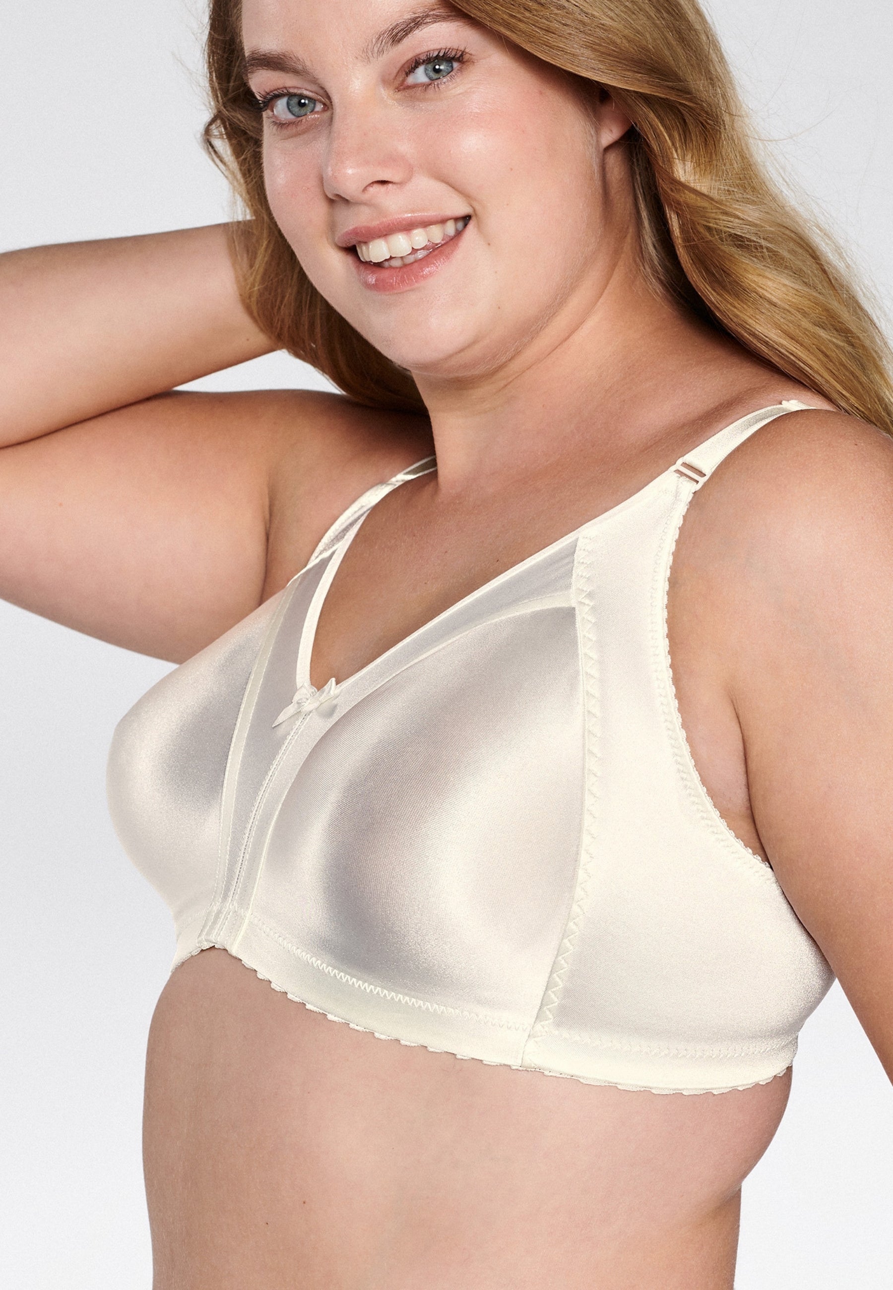 Zijde van vrouw die de minimizer bh met glanzend effect in de kleur ivoor van het merk Naturana draagt
