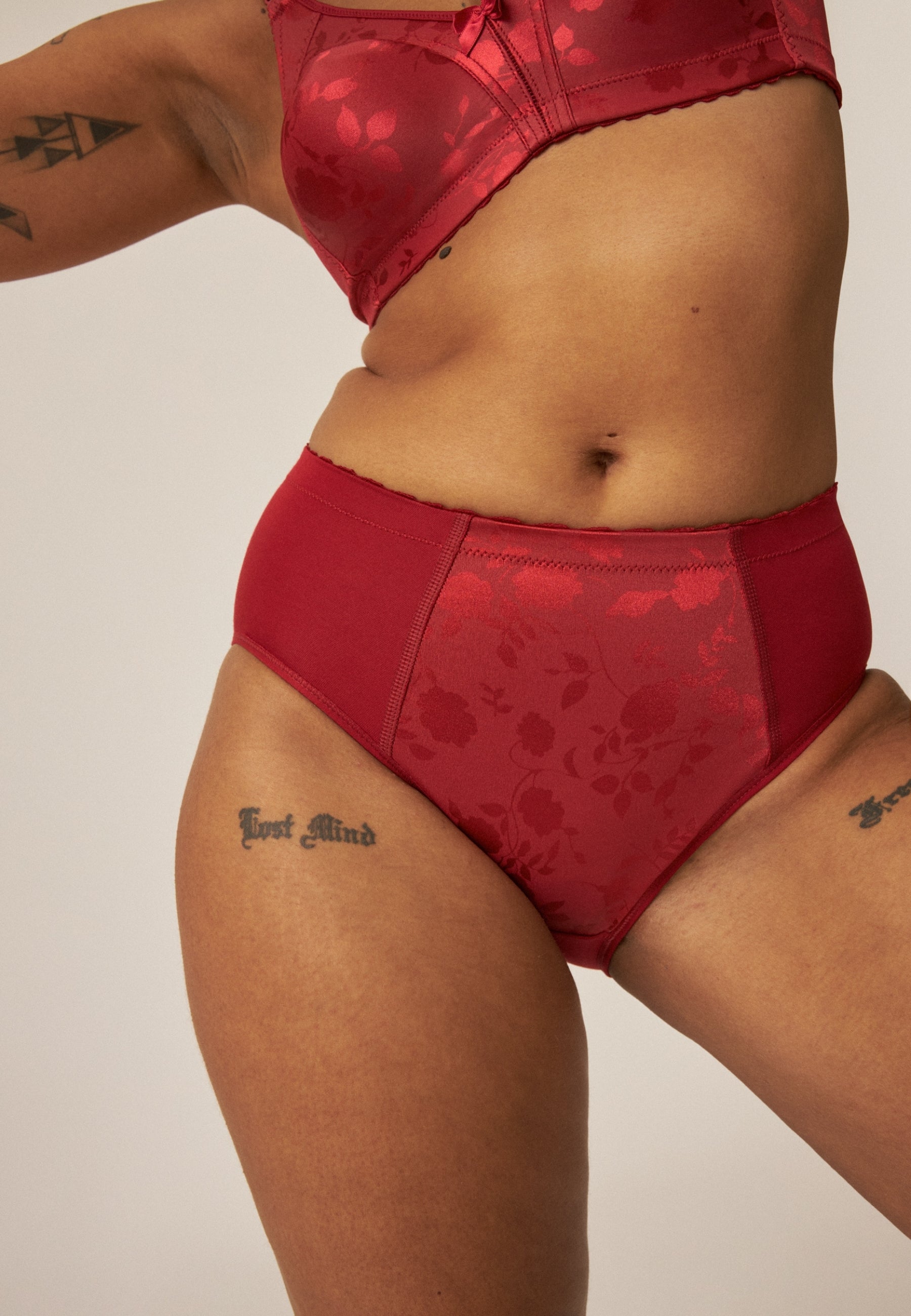 Voorzijde van vrouw die de minimizer bh en minimizer slip met bloemenpatroon in de kleur deep claret van het merk Naturana draagt