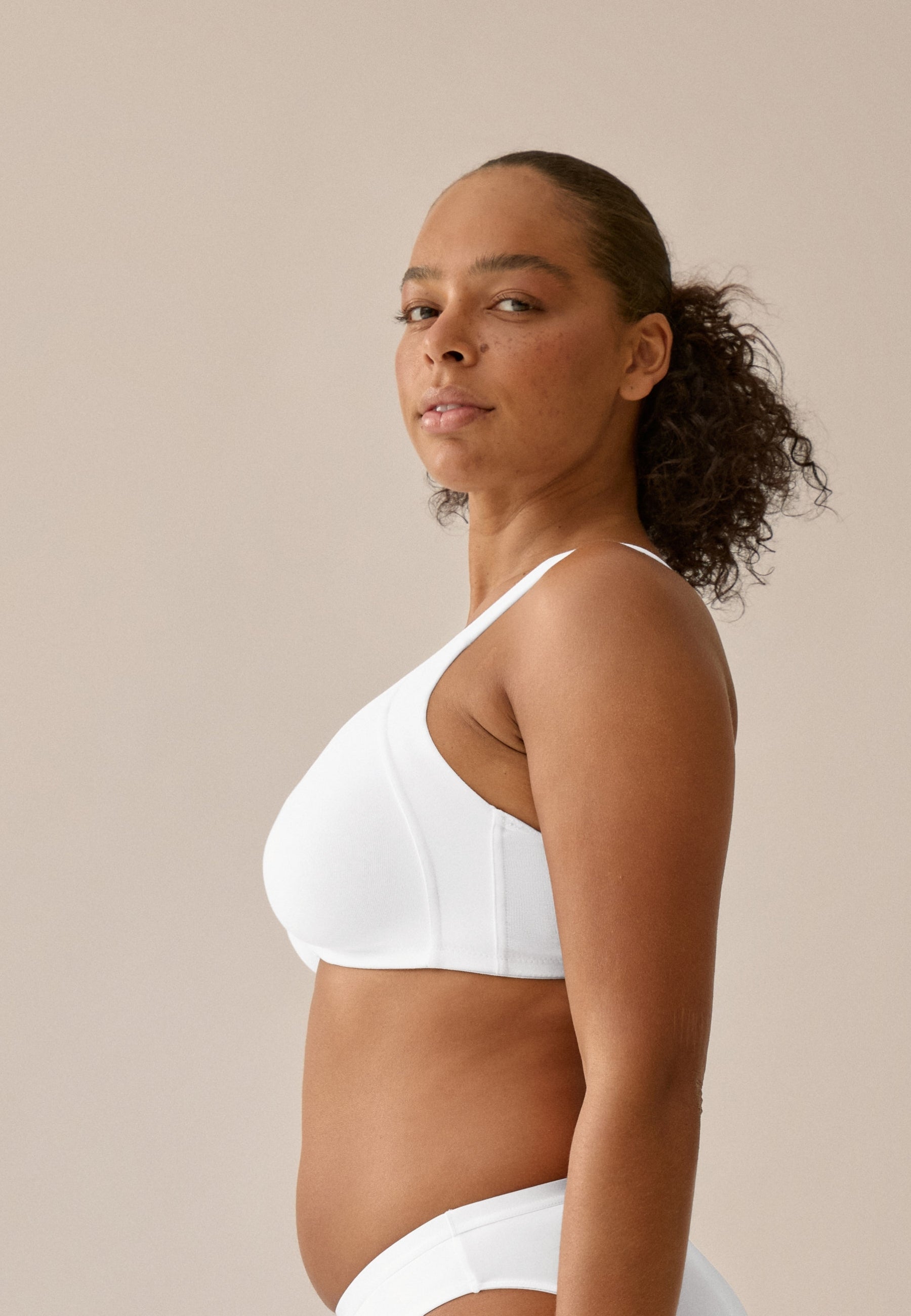 Zijde van vrouw die de katoenen minimizer bh met side smoother in de kleur wit van het merk Naturana draagt