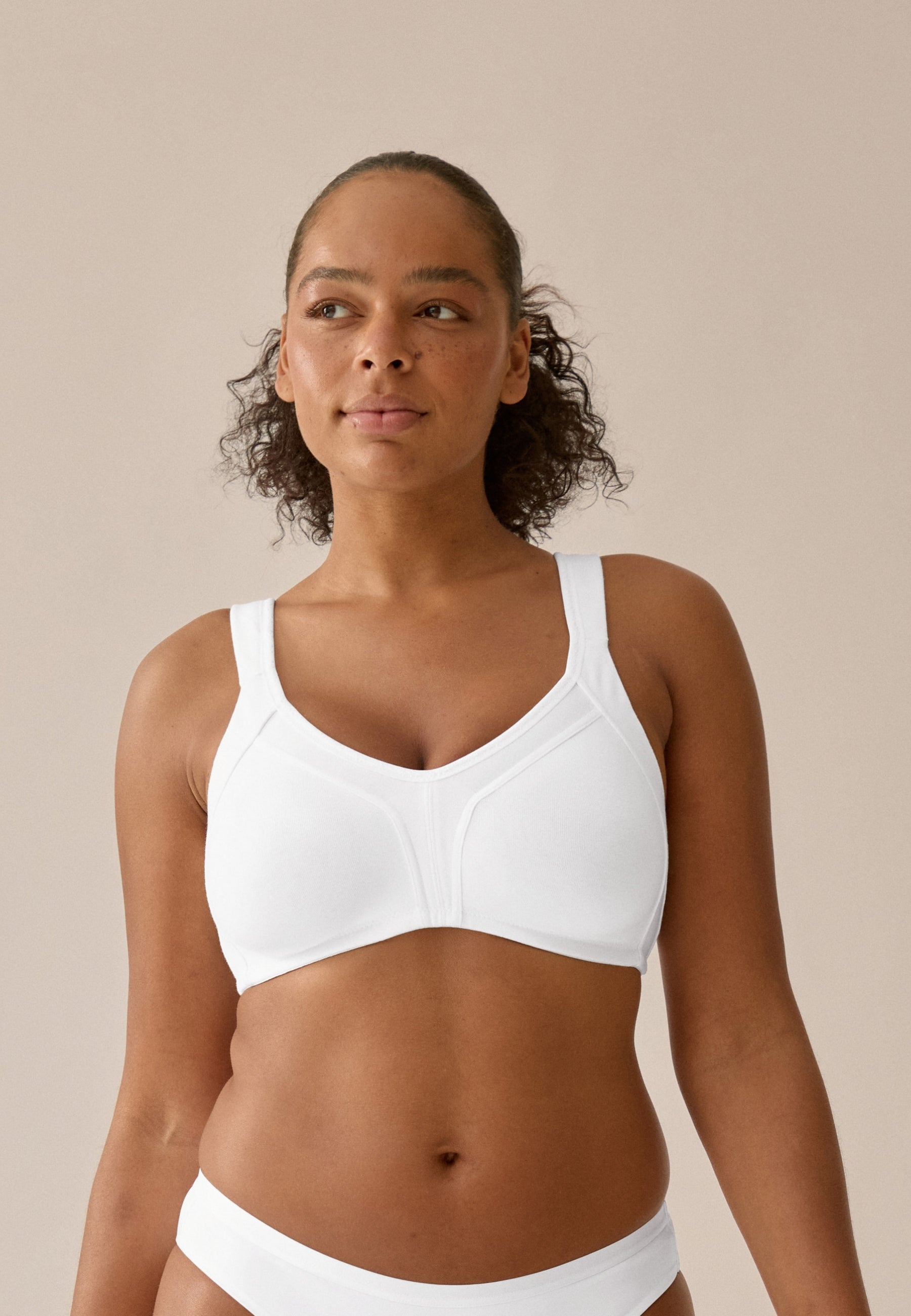 Voorzijde van vrouw die de katoenen minimizer bh met side smoother in de kleur wit van het merk Naturana draagt