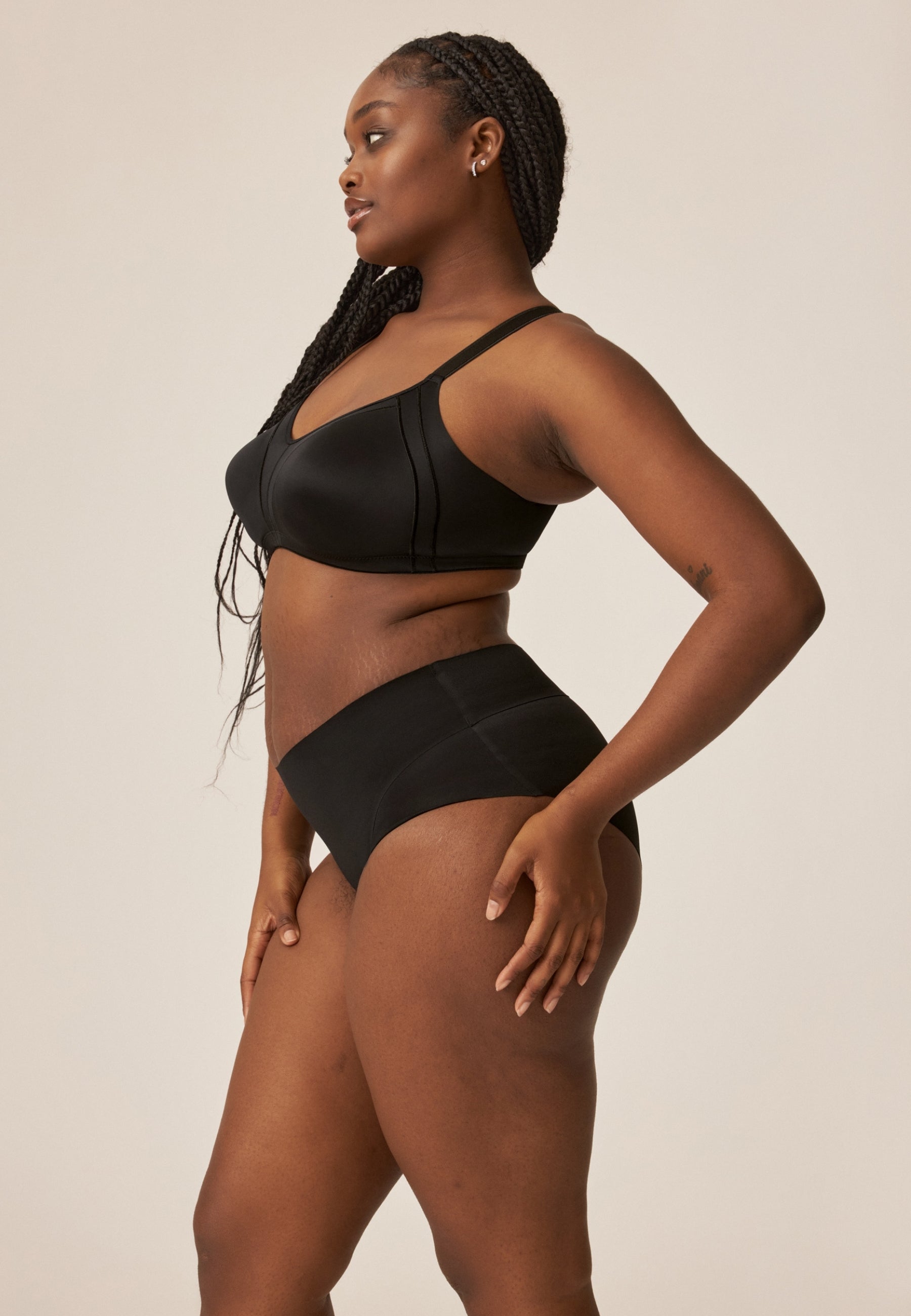 Zijde van vrouw die de minimizer bh met side smoother in de kleur zwart van het merk Naturana draagt