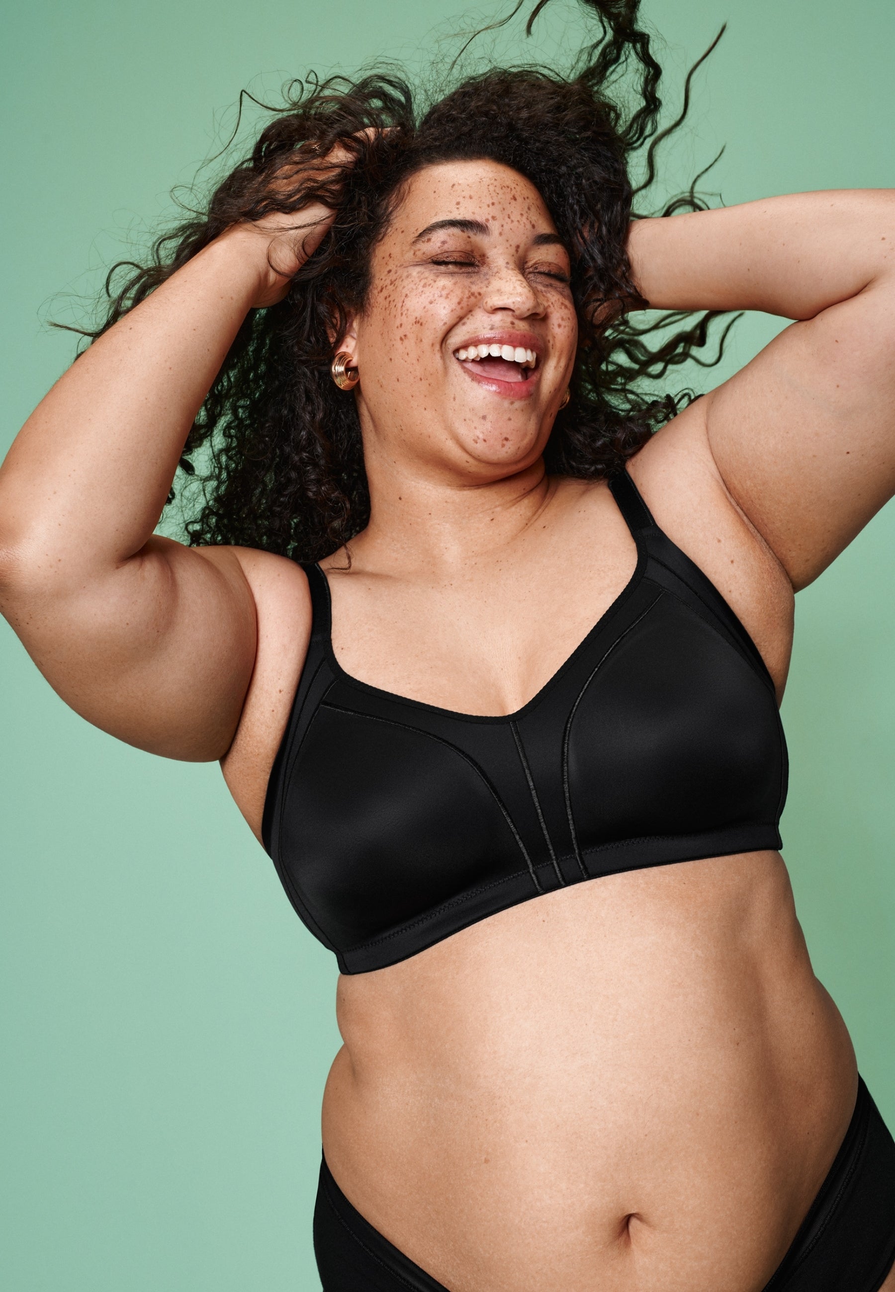 Voorzijde van vrouw die de minimizer bh met side smoother in de kleur zwart van het merk Naturana draagt