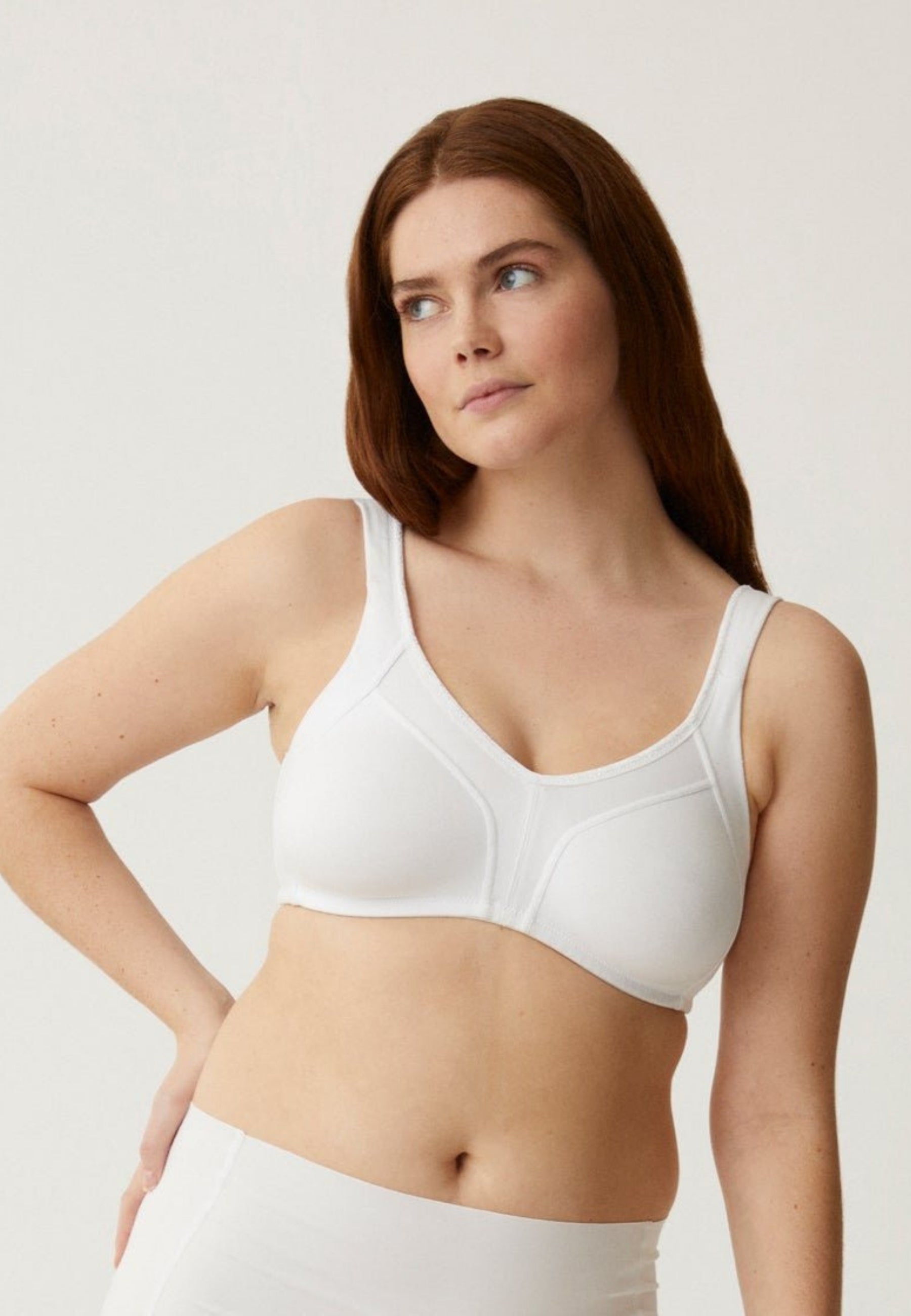 Voorzijde van vrouw die de katoenen minimizer bh met side smoother in de kleur wit van het merk Naturana draagt