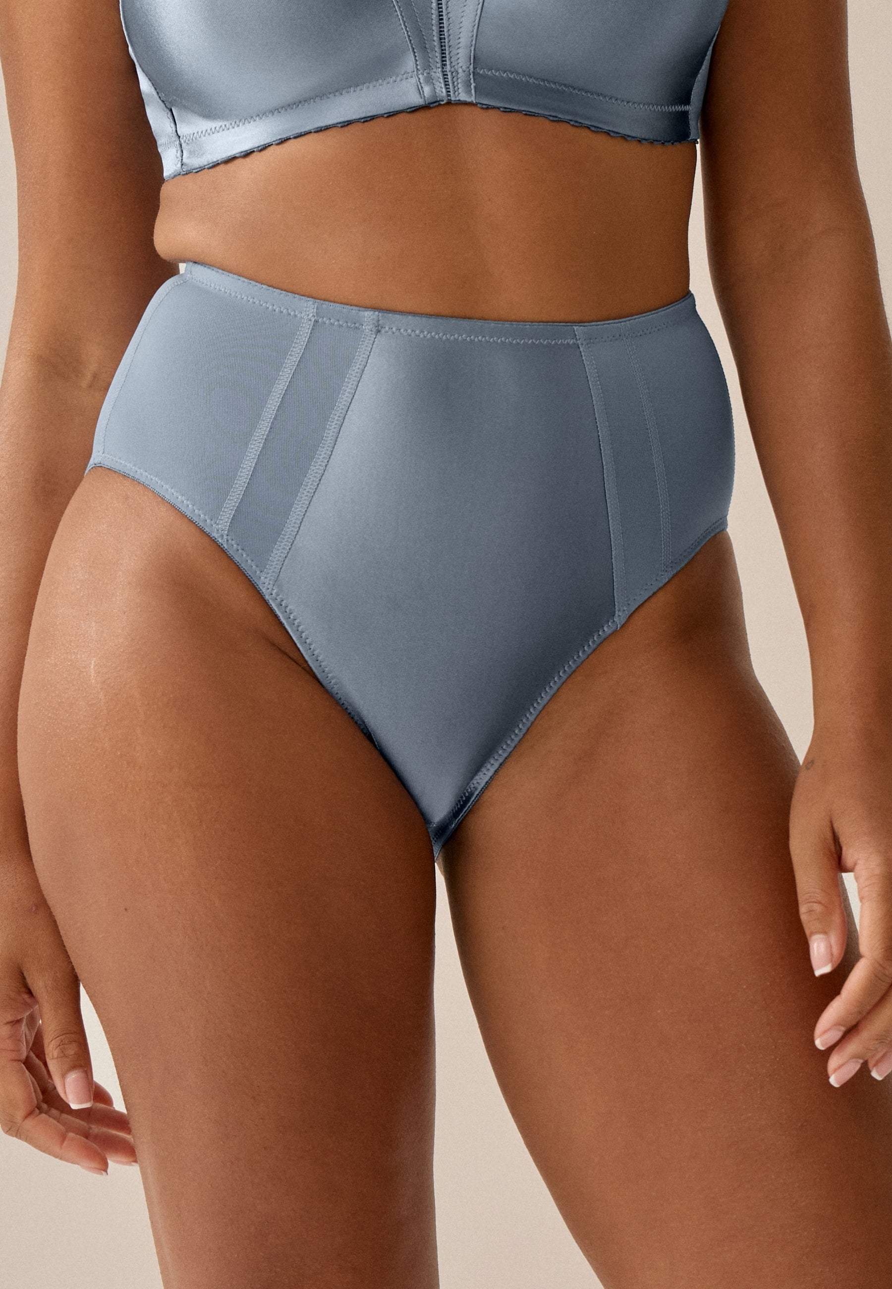 Voorzijde van vrouw die de minimizer slip met glanzend effect in de kleur moonlight blue van het merk Naturana draagt