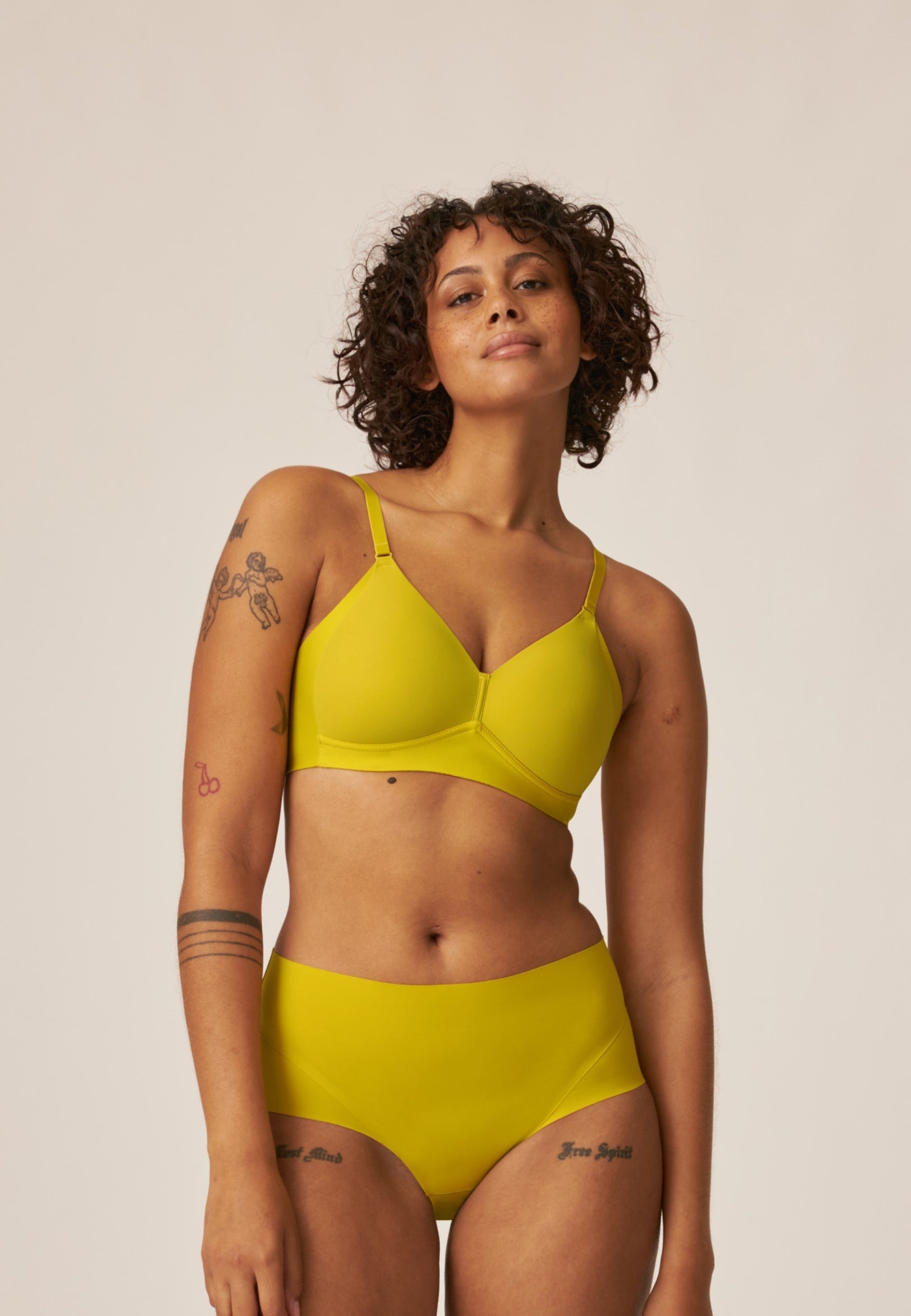 Voorzijde van vrouw die de side smoother bh en high waist slip in de kleur golden olive van het merk Naturana draagt