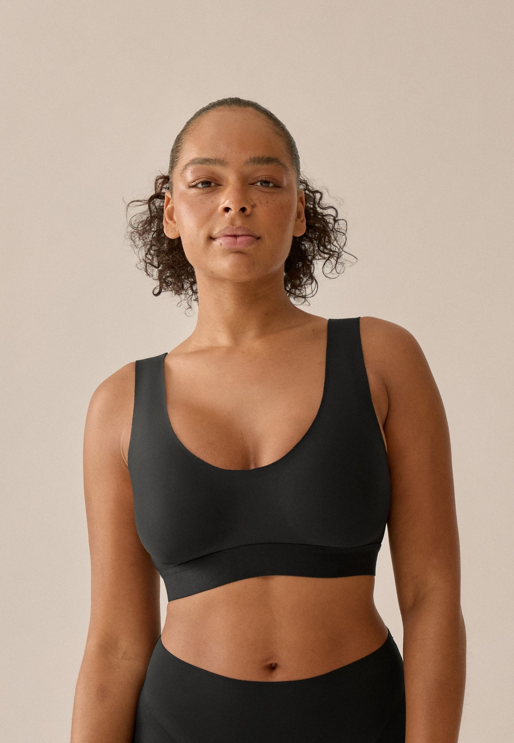 Voorzijde van vrouw die de smoothing bh in de kleur zwart van het merk Naturana draagt