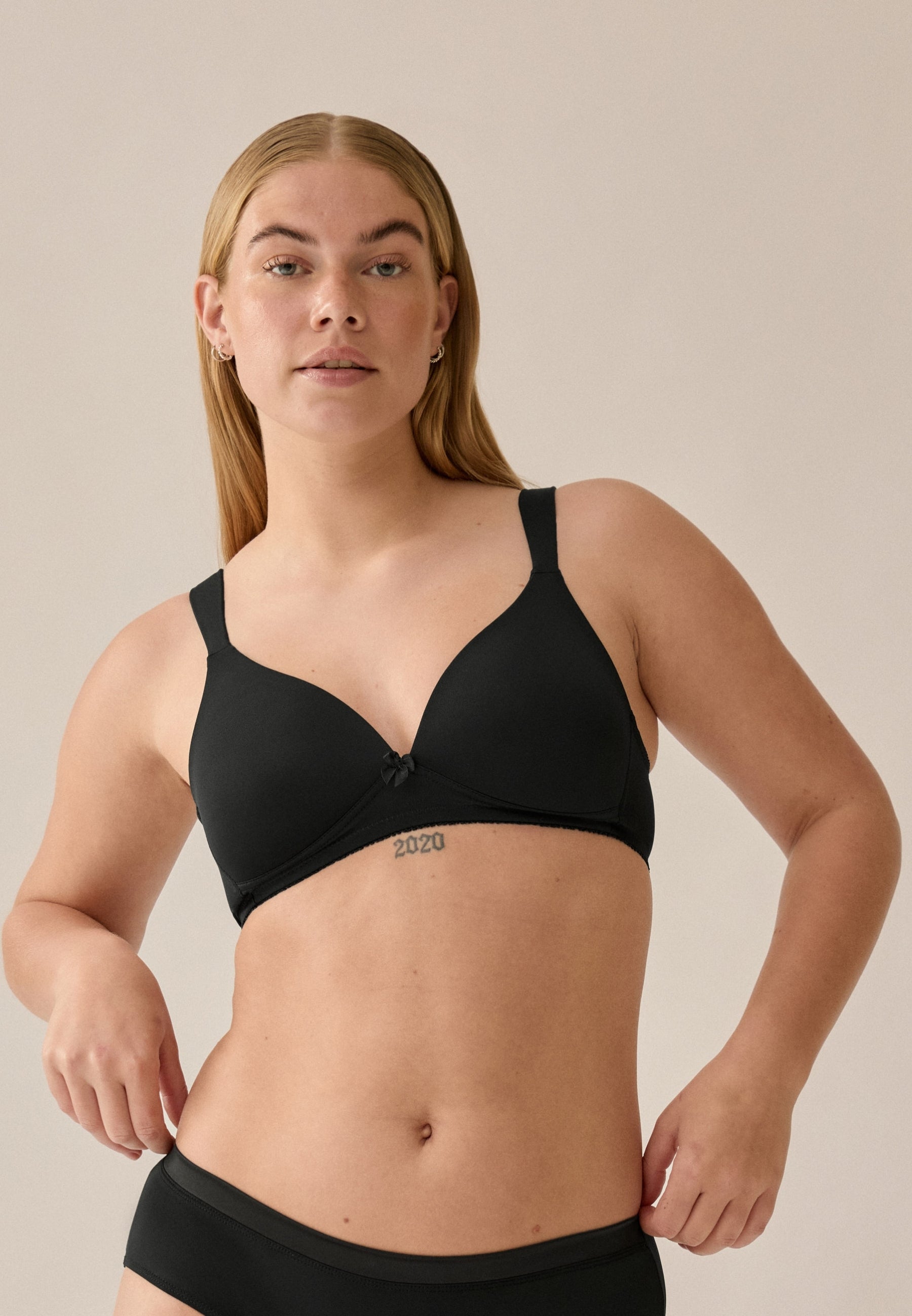 Voorzijde van vrouw die de soft bh met brede bandjes in de kleur zwart van het merk Naturana draagt