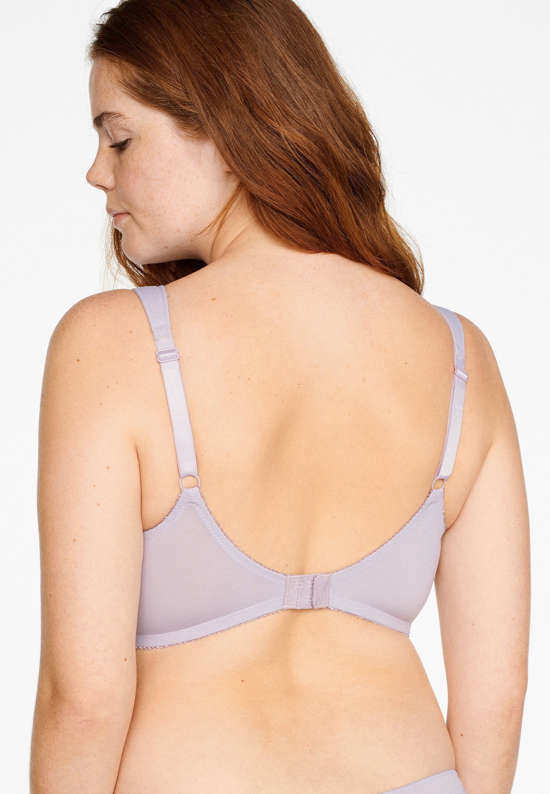 Achterzijde van vrouw die de soft bh met brede bandjes in de kleur blueberry cream van het merk Naturana draagt