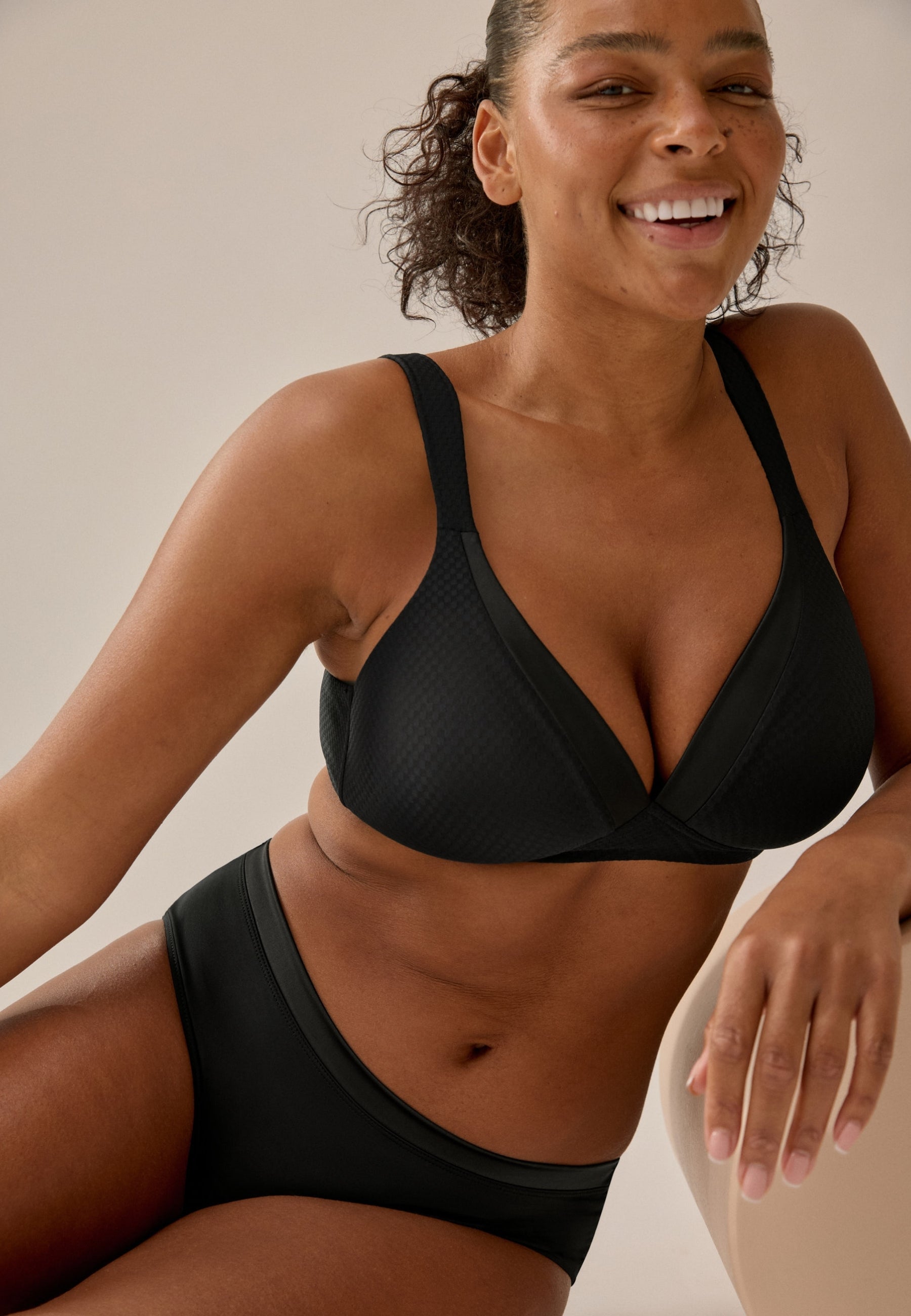 Voorzijde van vrouw die de soft bh met glansband en patroon in de kleur zwart van het merk Naturana draagt