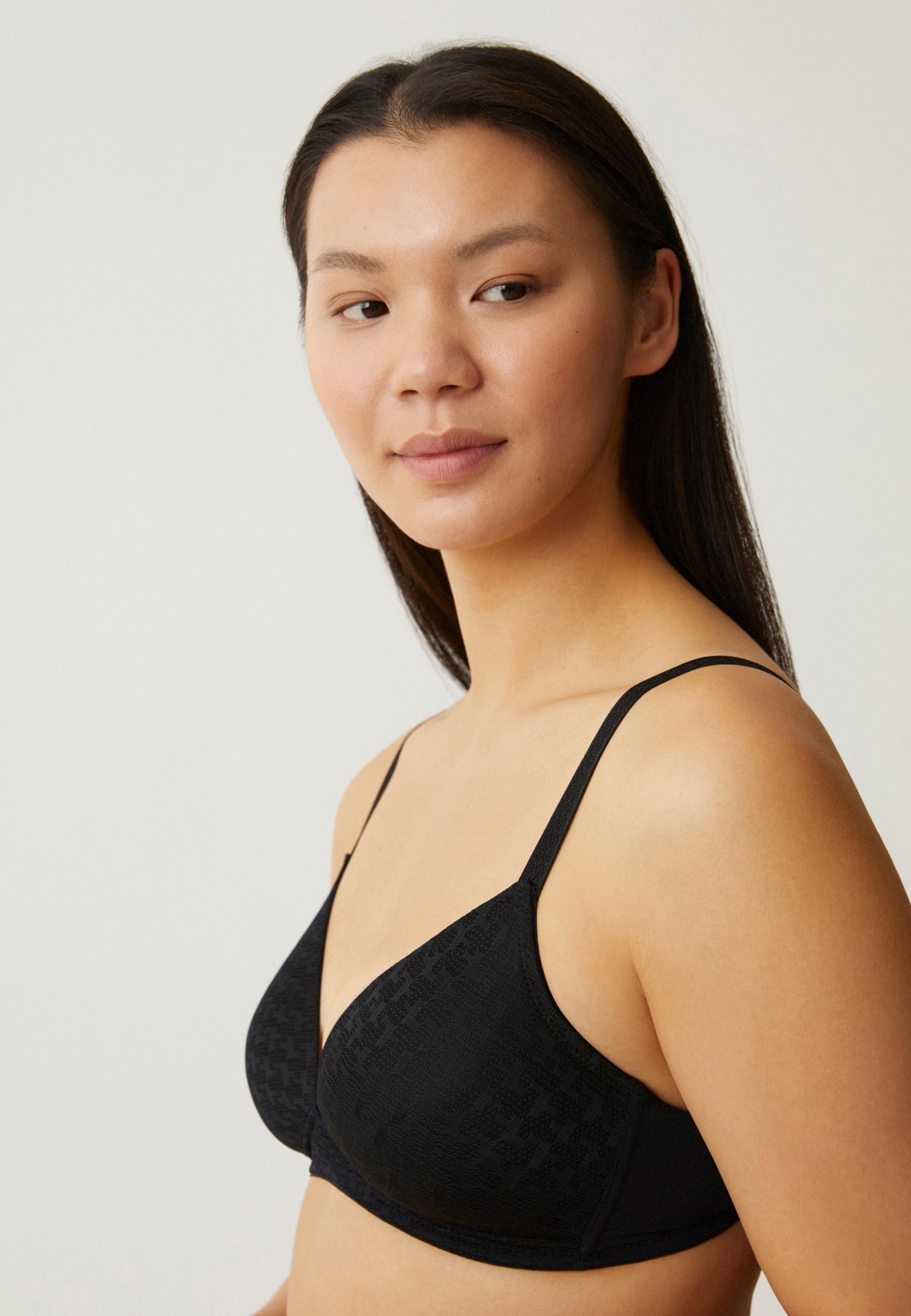 Zijde van vrouw die de soft bh met pied de poule patroon in de kleur zwart van het merk Naturana draagt