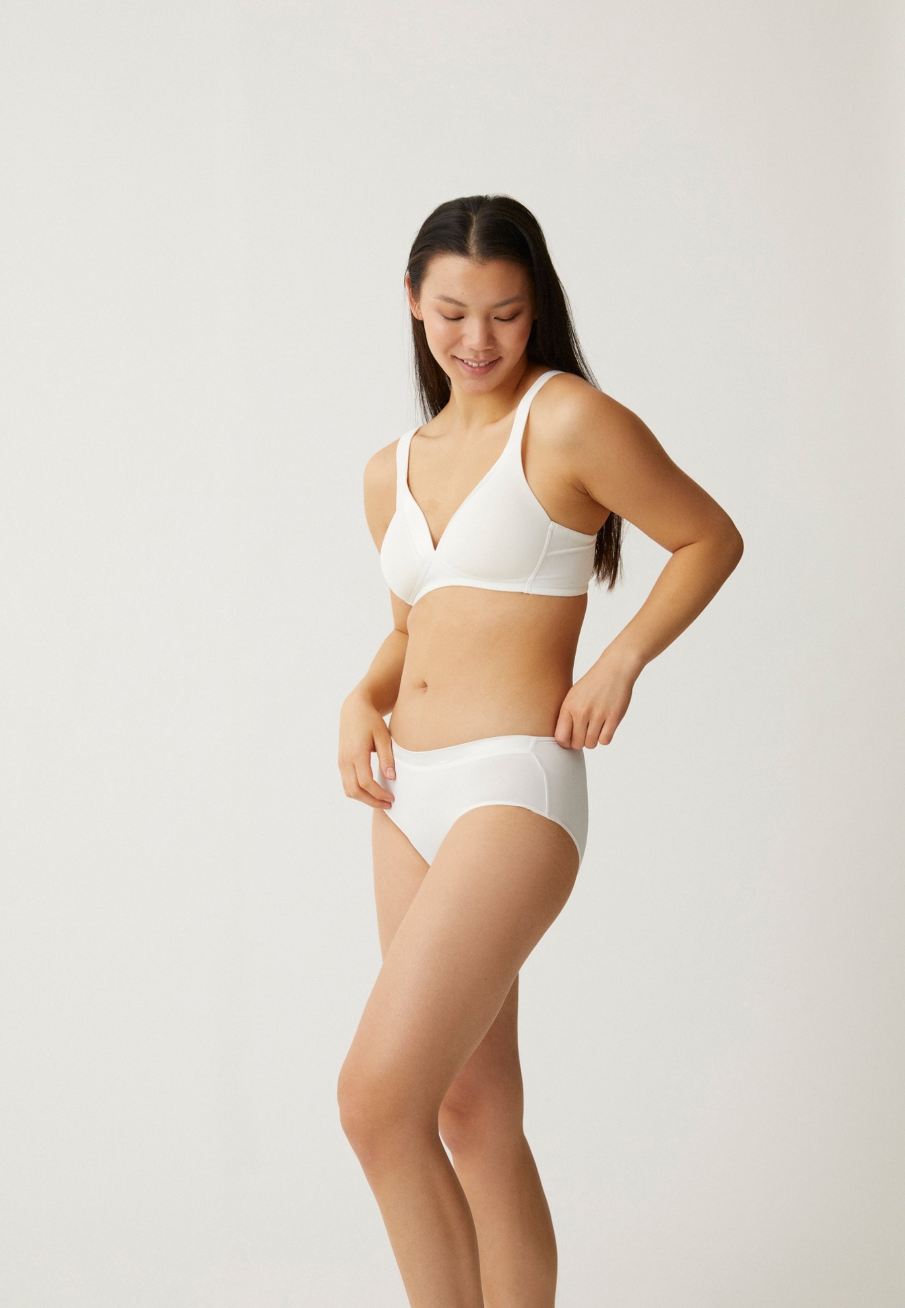 Zijde van vrouw die de soft bh met glansband en slip met glansband in de kleur ecru van het merk Naturana draagt