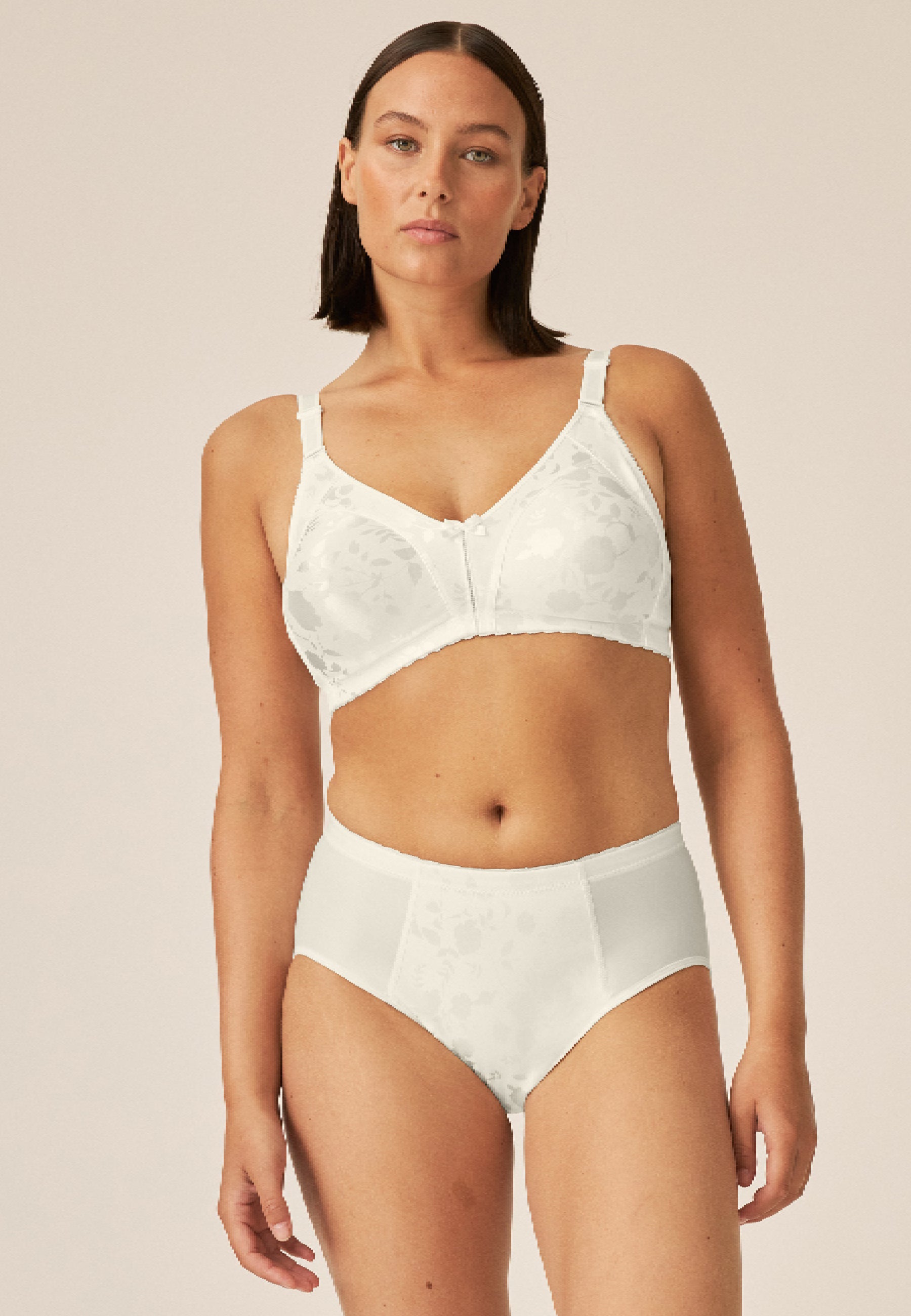 Voorzijde van vrouw die de minimizer bh met bloemenpatroon en slip met bloemenpatroon in de kleur Ivoor van het merk Naturana draagt