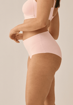 Zijde van vrouw die de high waist slip in de kleur blush van het merk Naturana draagt