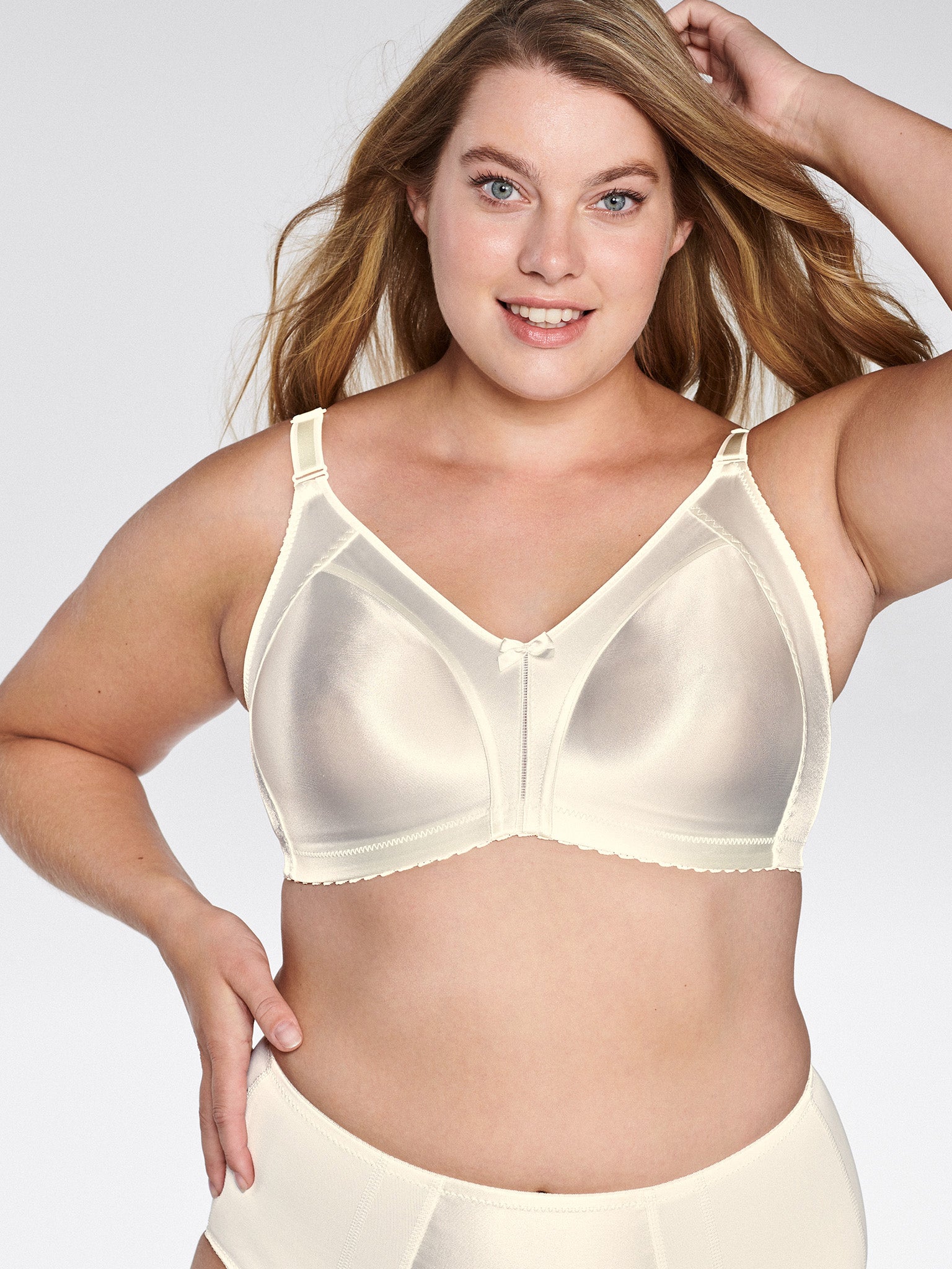 Voorzijde van vrouw die de minimizer bh met glanzend patroon in de kleur Ivoor van het merk Naturana draagt