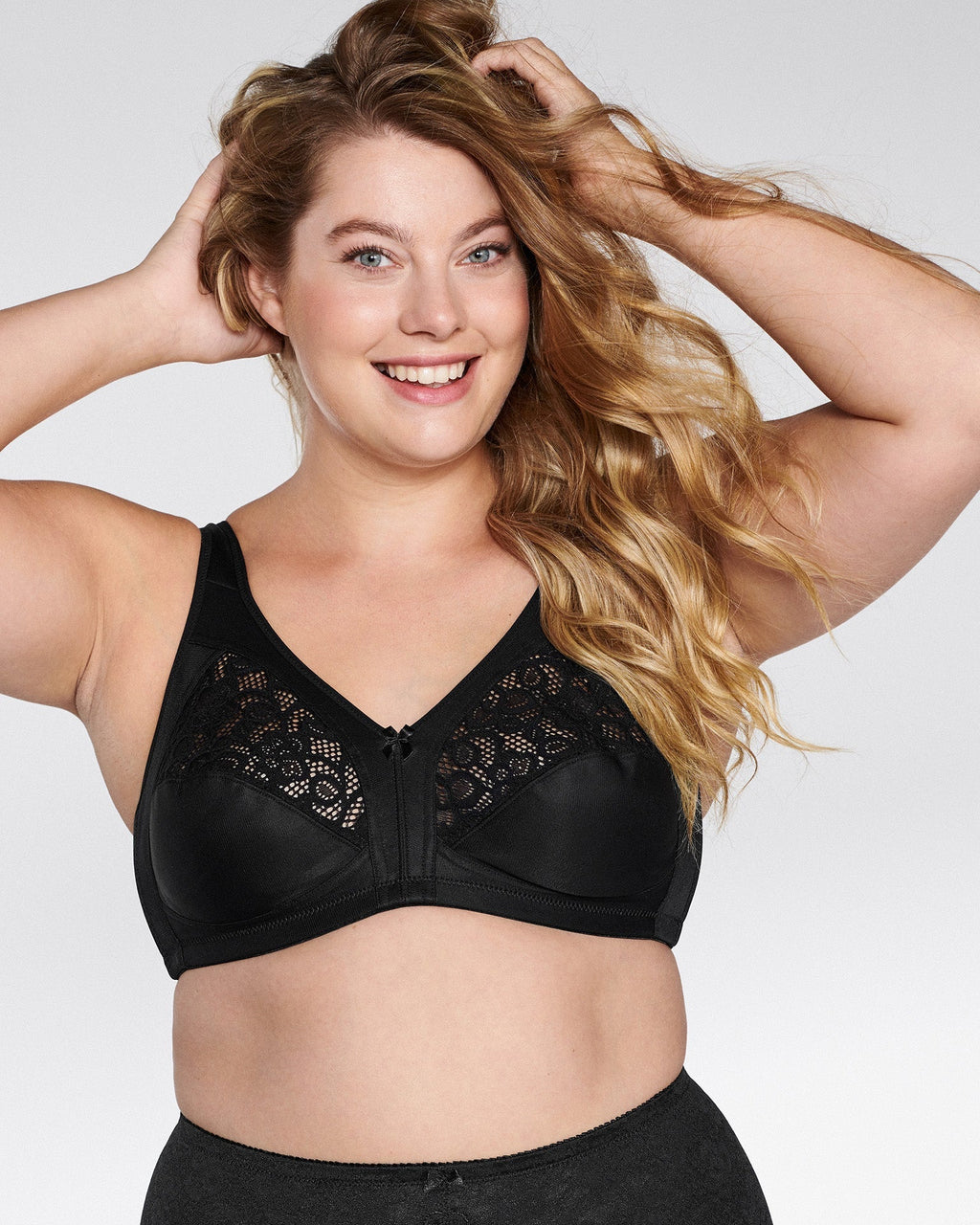 Voorzijde van vrouw die de soft bh met kant in de kleur zwart van het merk Naturana draagt
