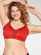 Voorzijde van vrouw die de minimizer bh met side smoother in de kleur rood van het merk Naturana draagt