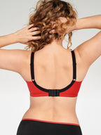 Achterzijde van vrouw die de minimizer bh met side smoother in de kleur rood van het merk Naturana draagt