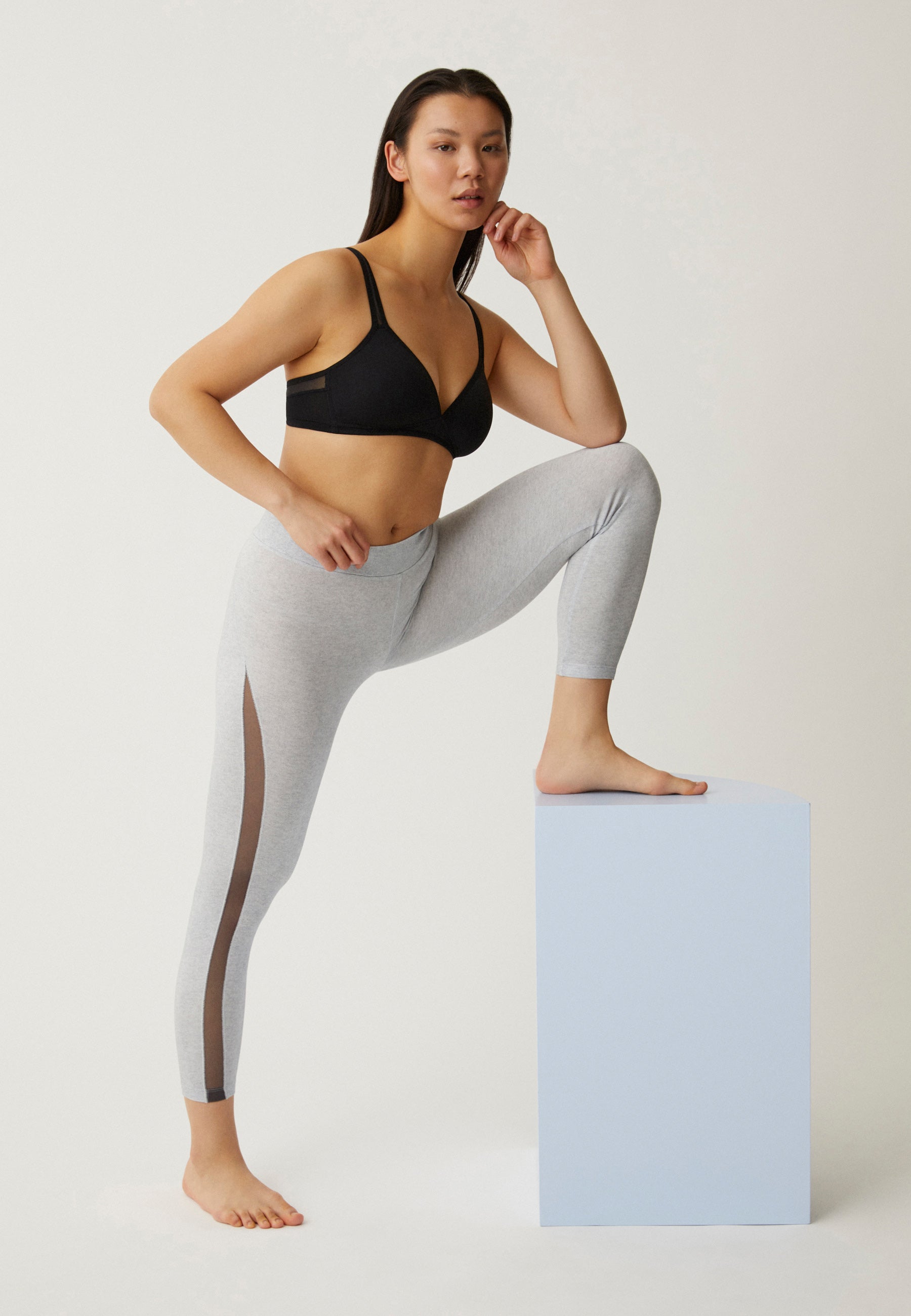 Zijde van vrouw die de soft bh met mesh bandjes in de kleur zwart van het merk Naturana draagt
