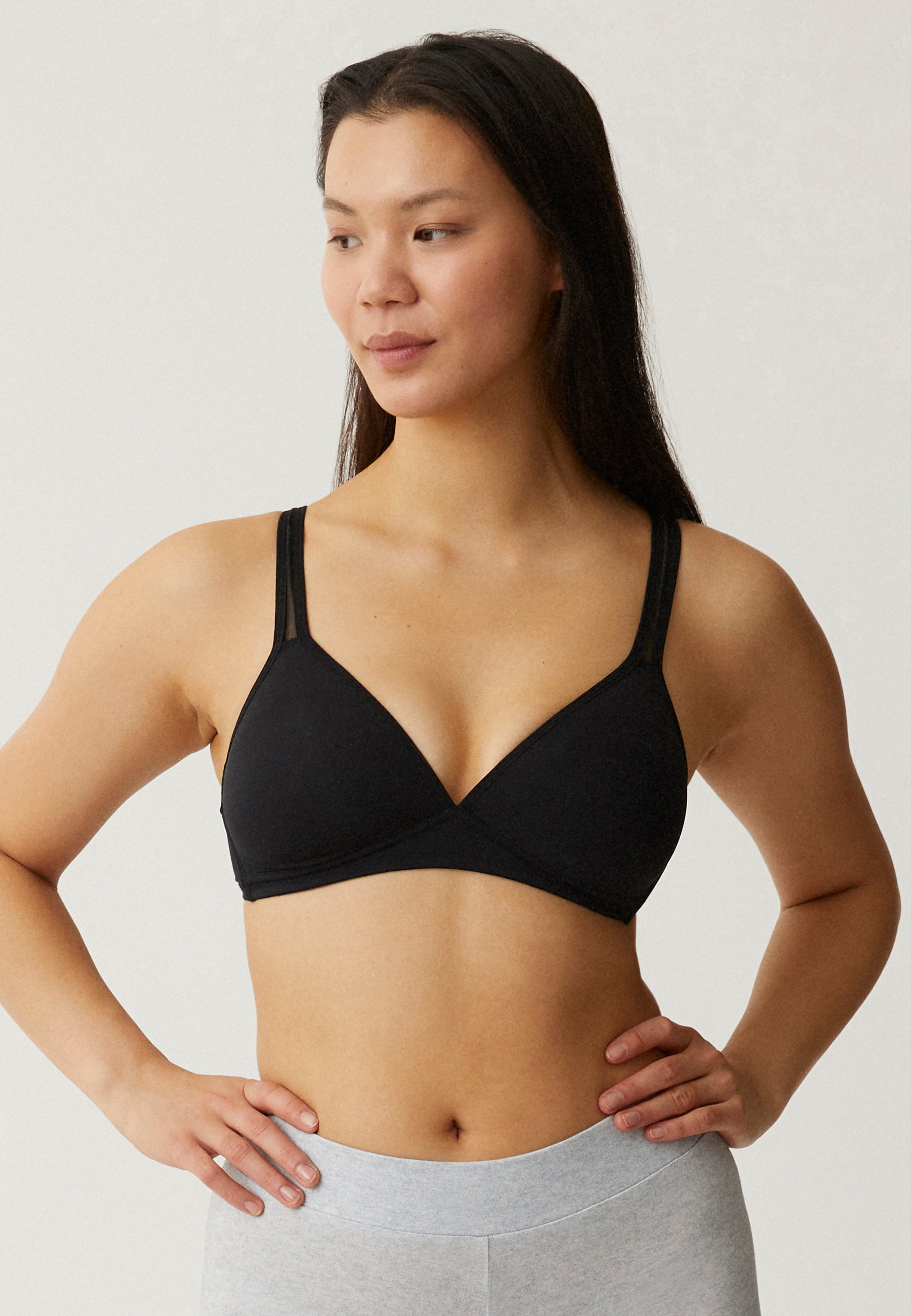 Voorzijde van vrouw die de soft bh met mesh bandjes in de kleur zwart van het merk Naturana draagt