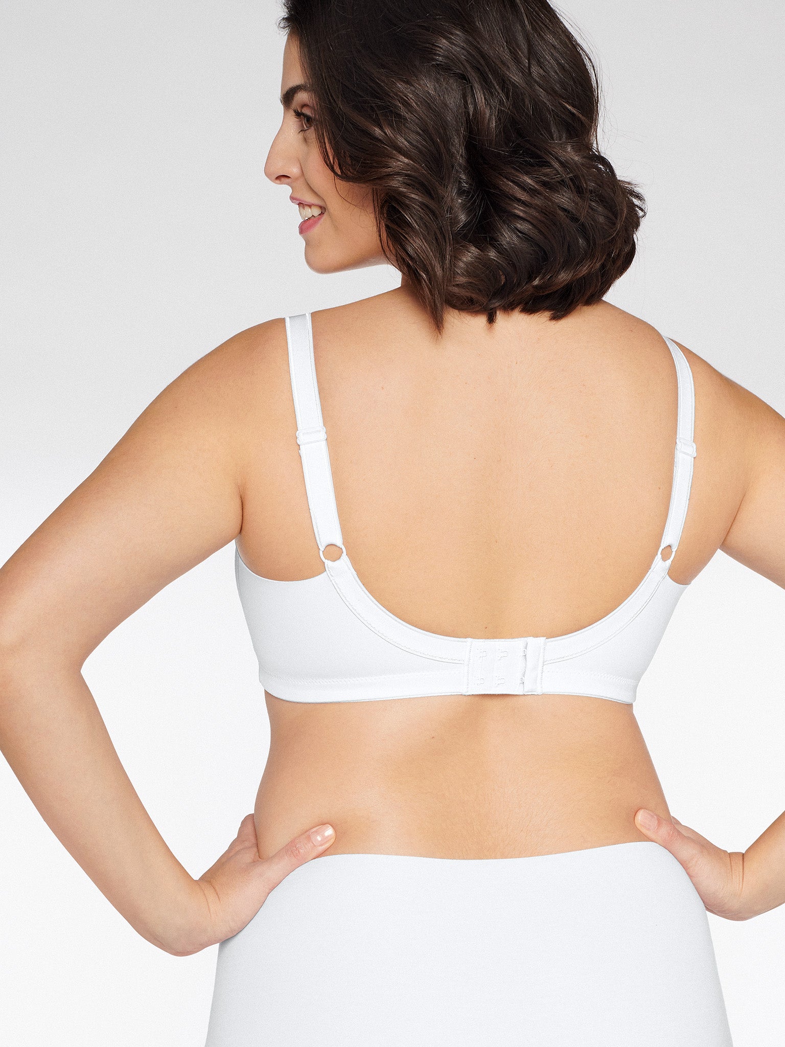 Achterzijde van vrouw die de minimizer bh met side smoother in de kleur wit van het merk Naturana draagt
