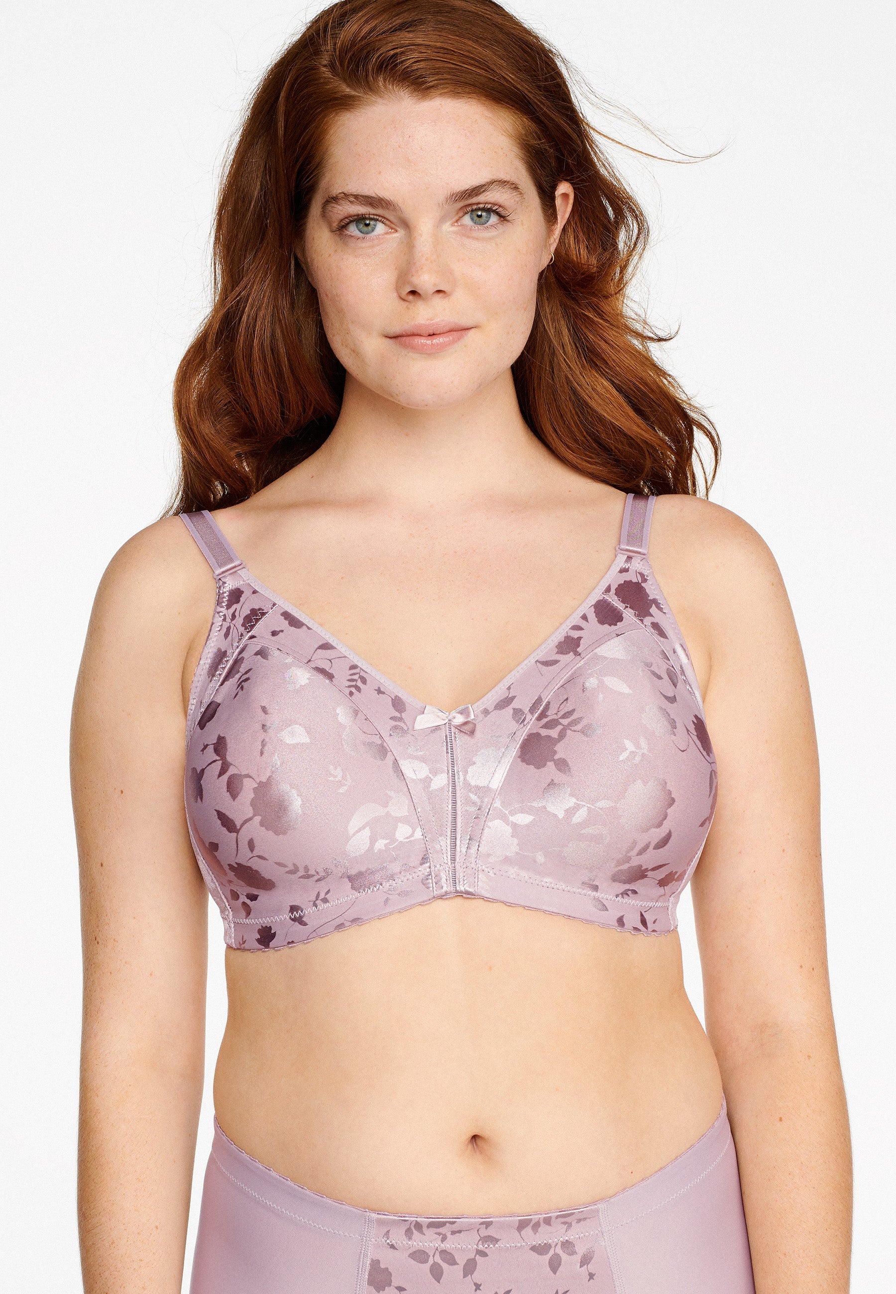 Voorzijde van vrouw die de minimizer bh met bloemenpatroon en slip met bloemenpatroon in de kleur Pearl van het merk Naturana draagt