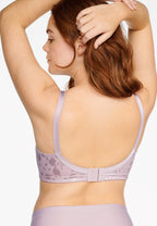 Achterzijde van vrouw die de minimizer bh met bloemenpatroon en slip met bloemenpatroon in de kleur Pearl van het merk Naturana draagt