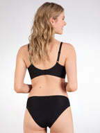 Achterzijde van vrouw die de side smoother bh zonder beugel in de kleur zwart van het merk Naturana draagt