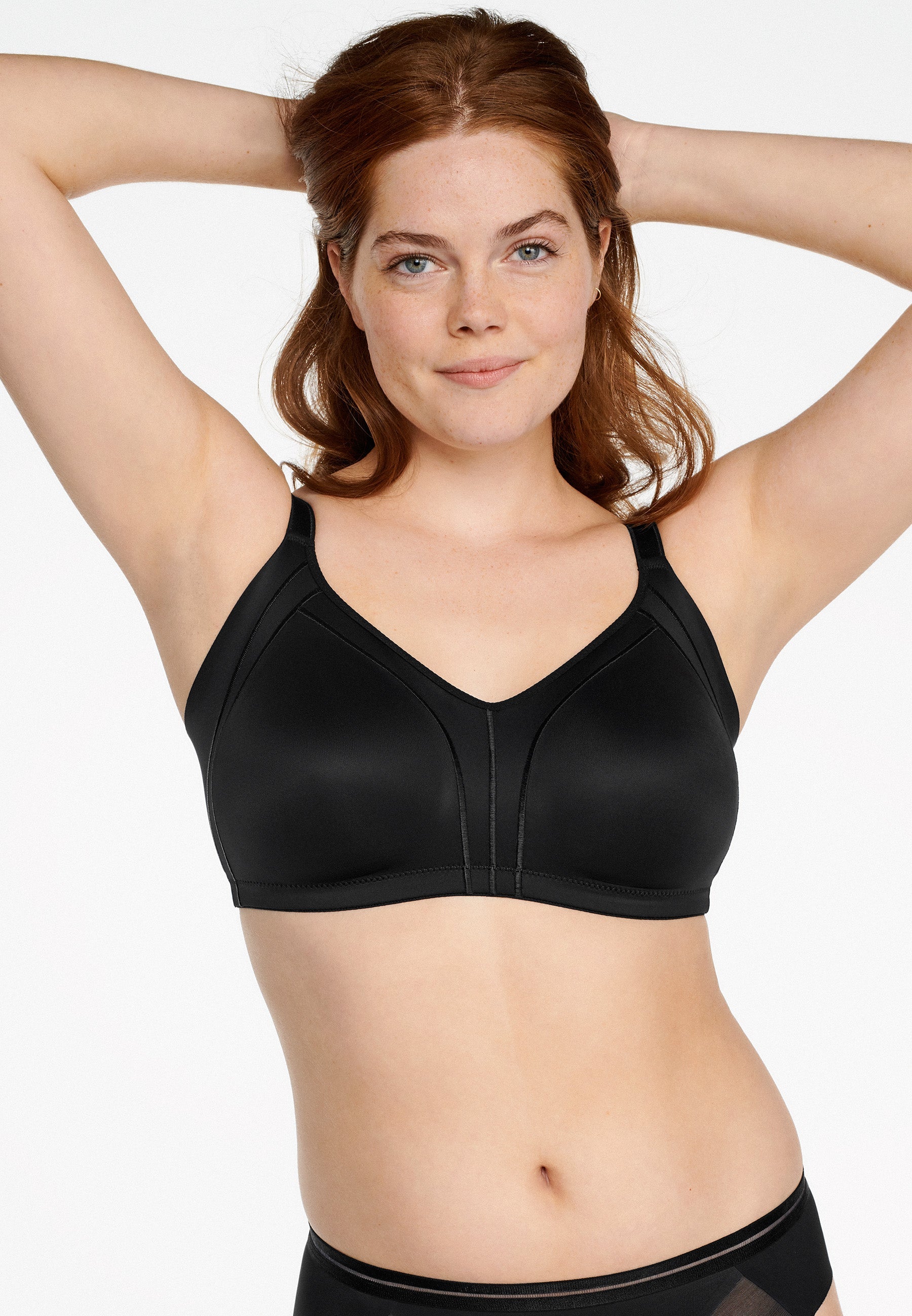 Voorzijde van vrouw die de minimizer bh met side smoother in de kleur zwart van het merk Naturana draagt