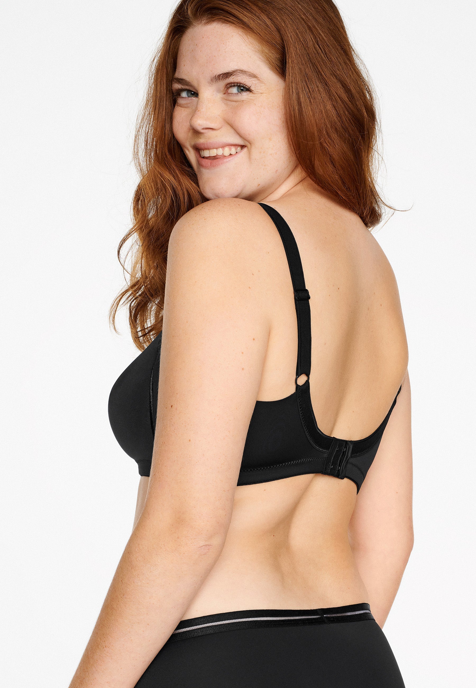 Achterzijde van vrouw die de minimizer bh met side smoother in de kleur zwart van het merk Naturana draagt