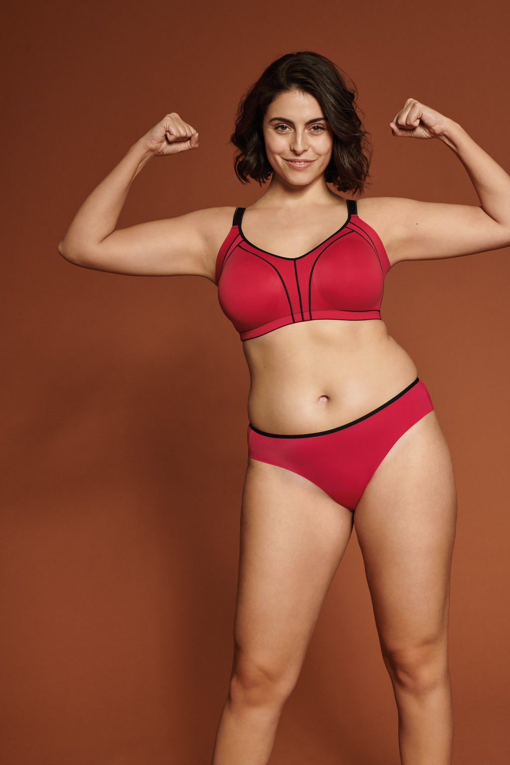 Voorzijde van vrouw die de minimizer bh met side smoother in de kleur rood van het merk Naturana draagt