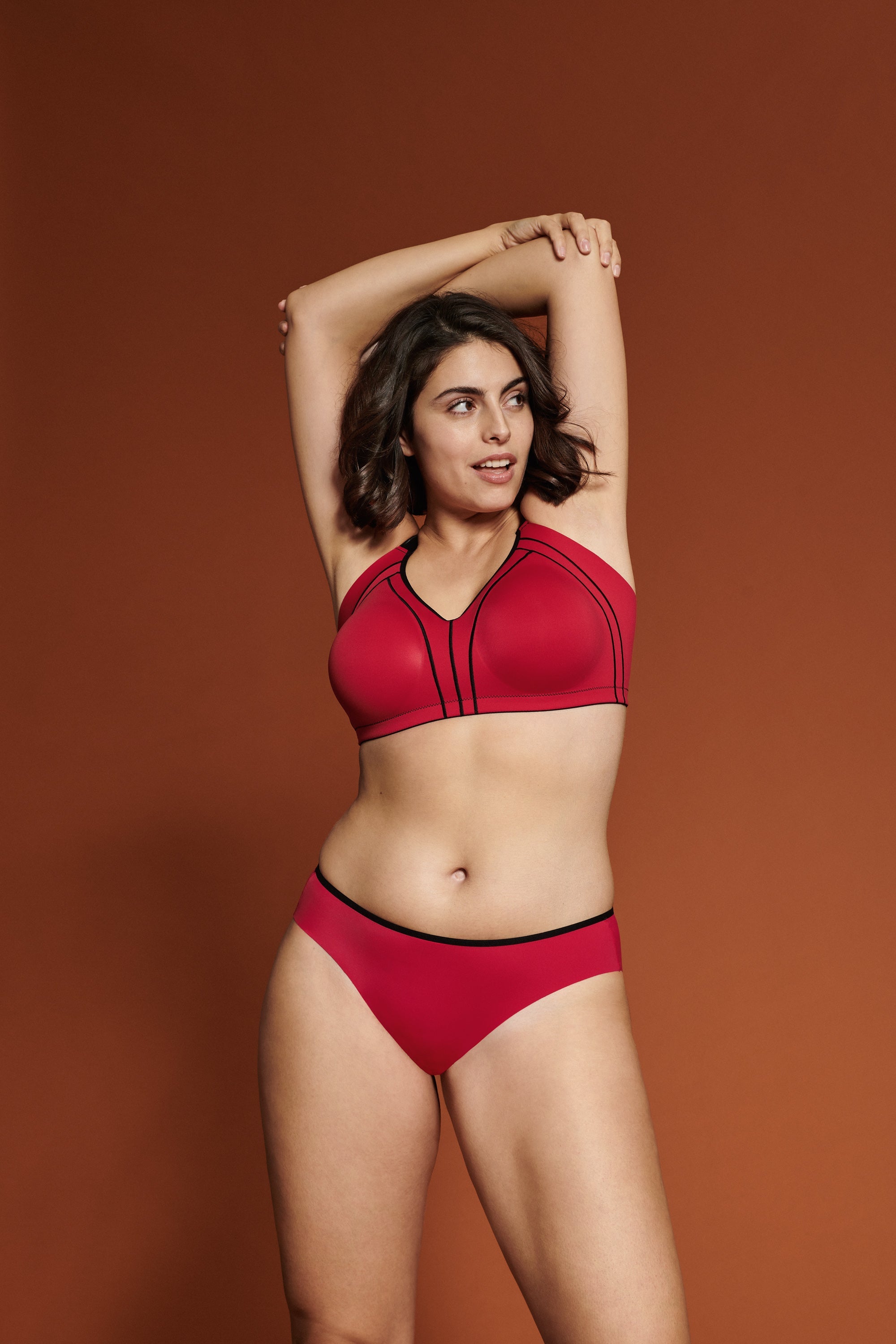 Voorzijde van vrouw die de minimizer bh met side smoother in de kleur rood van het merk Naturana draagt