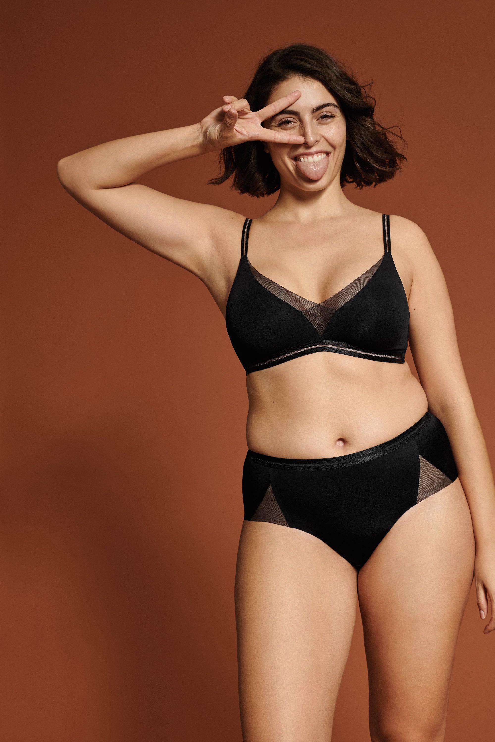 Voorzijde van vrouw die de soft bh met mesh detail en de slip met mesh detail in de kleur zwart van het merk Naturana draagt