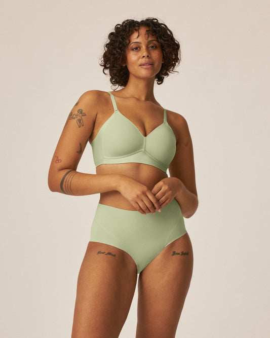 Voorzijde van vrouw die de side smoother bh en high waist slip in de kleur pale greenshield van het merk Naturana draagt