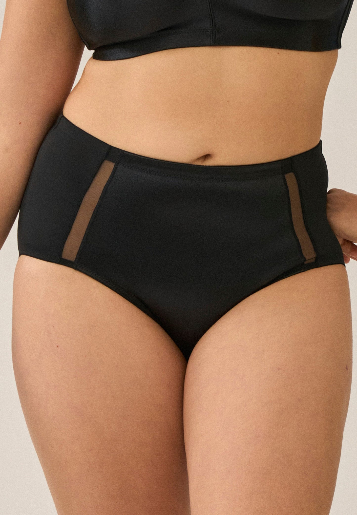 Voorzijde van vrouw die de hoge minimizer slip met mesh detail in de kleur zwart van het merk Naturana draagt