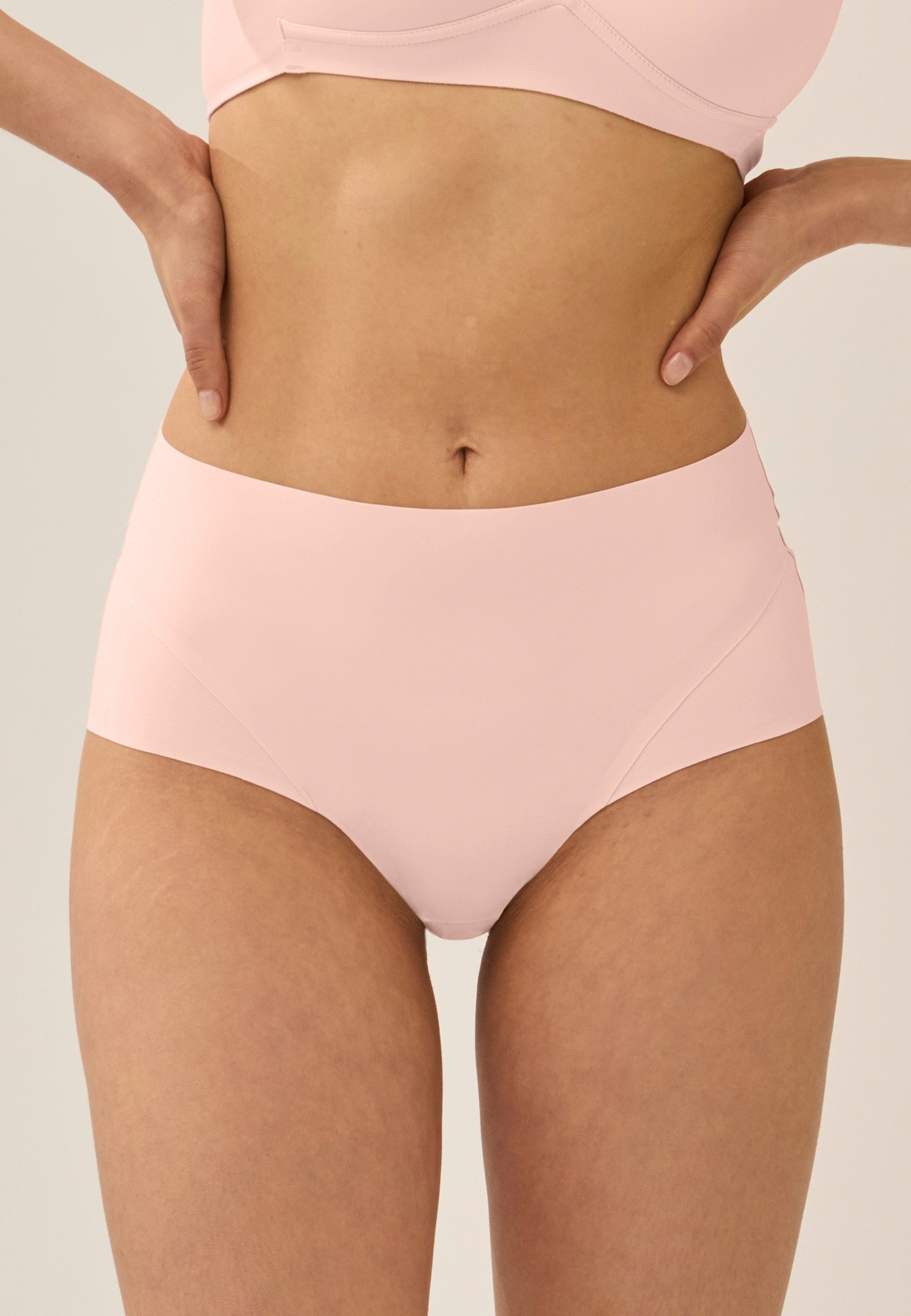Voorzijde van vrouw die de side smoother bh en high waist slip in de kleur blush van het merk Naturana draagt