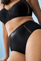 Zijde van vrouw die de minimizer bh met mesh detail en hoge minimizer slip met mesh detail in de kleur zwart van het merk Naturana draagt