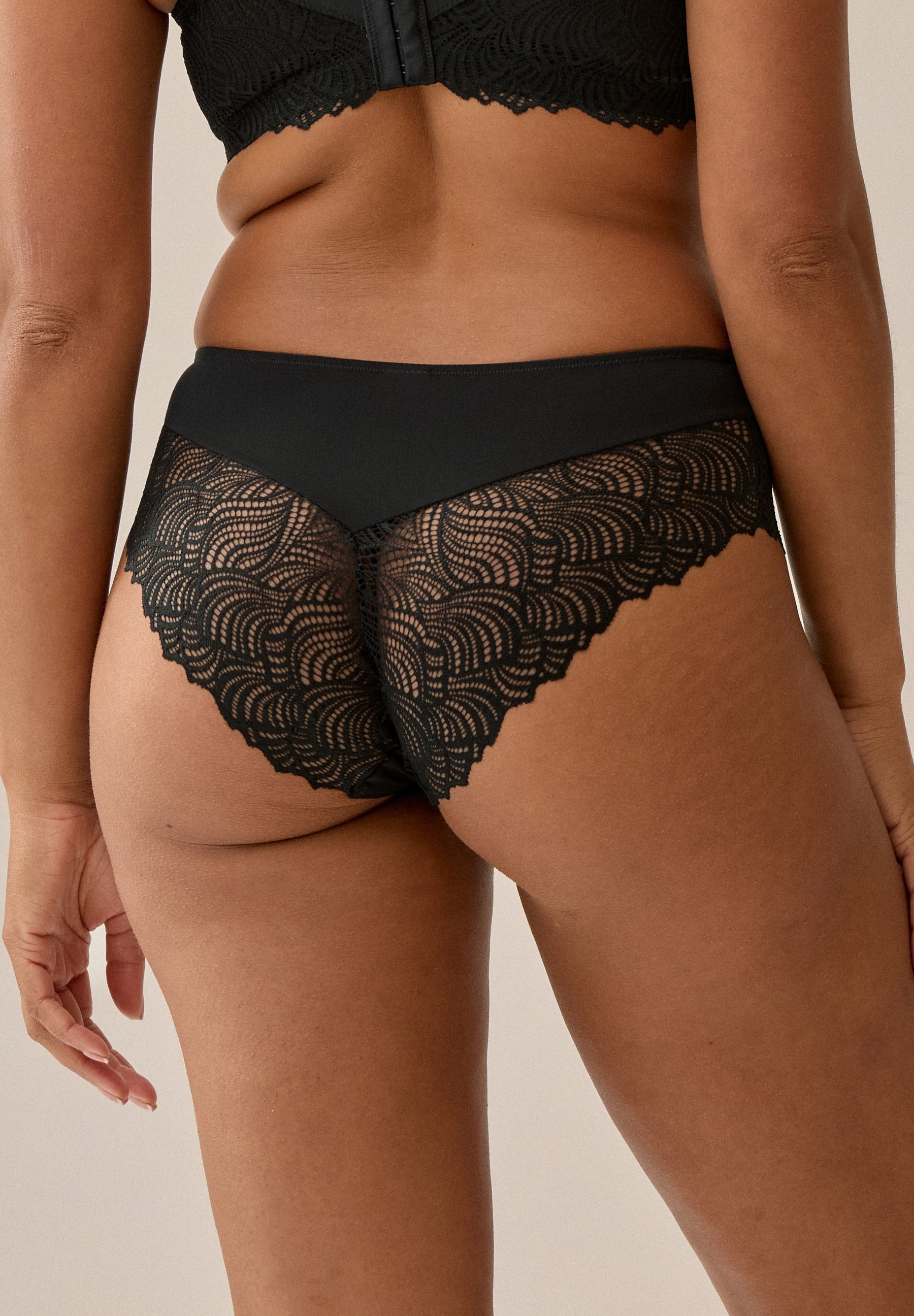 Achterzijde van vrouw die de hipster met kant in de kleur zwart van het merk Naturana draagt