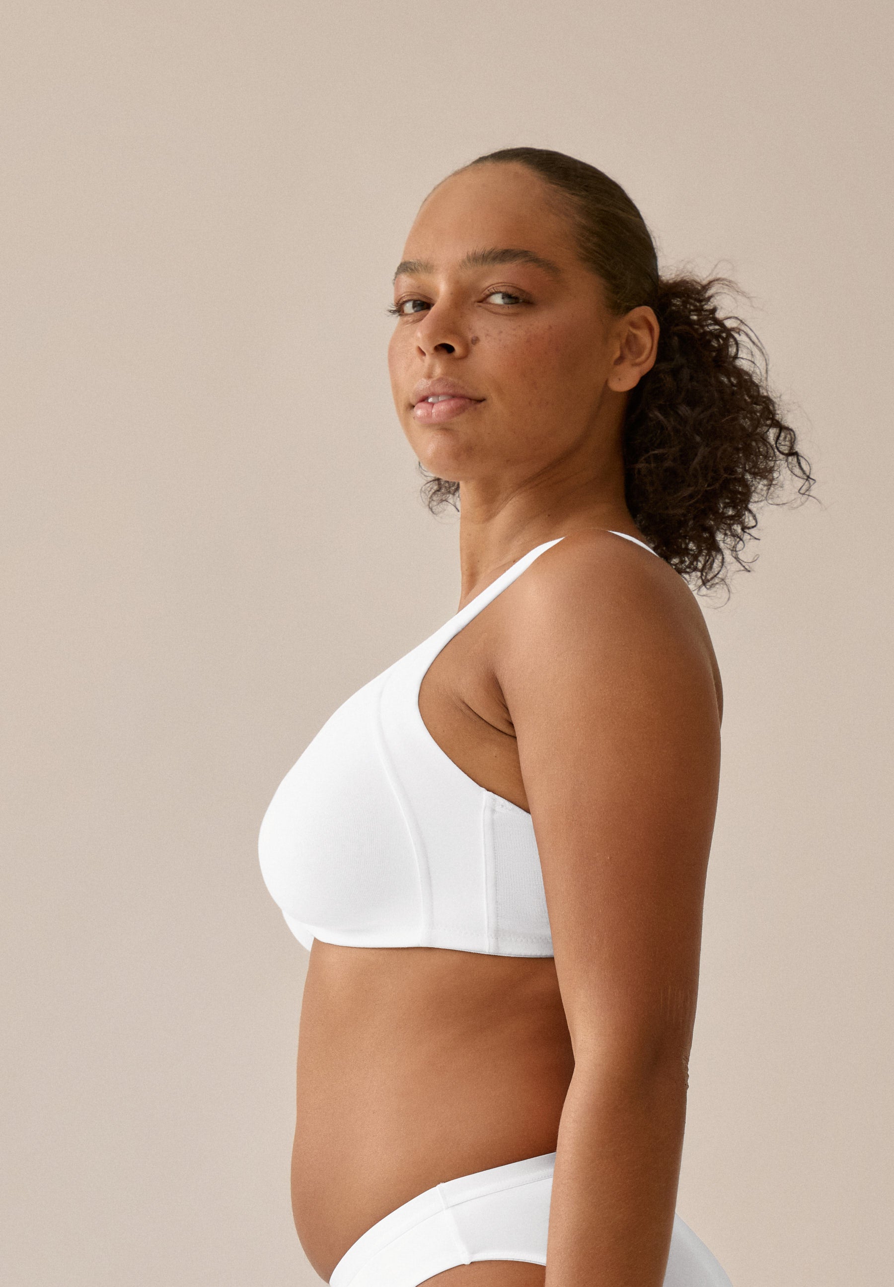 Zijde van vrouw die de katoenen minimizer met side smoother in de kleur wit van het merk Naturana draagt