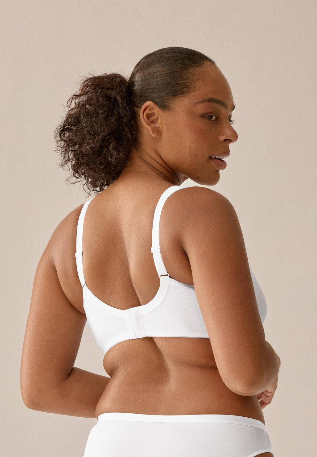 Achterzijde van vrouw die de katoenen minimizer met side smoother in de kleur wit van het merk Naturana draagt