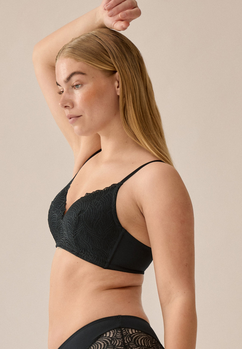 Zijde van vrouw die de voorgevormde soft bh met kant in de kleur zwart van het merk Naturana draagt