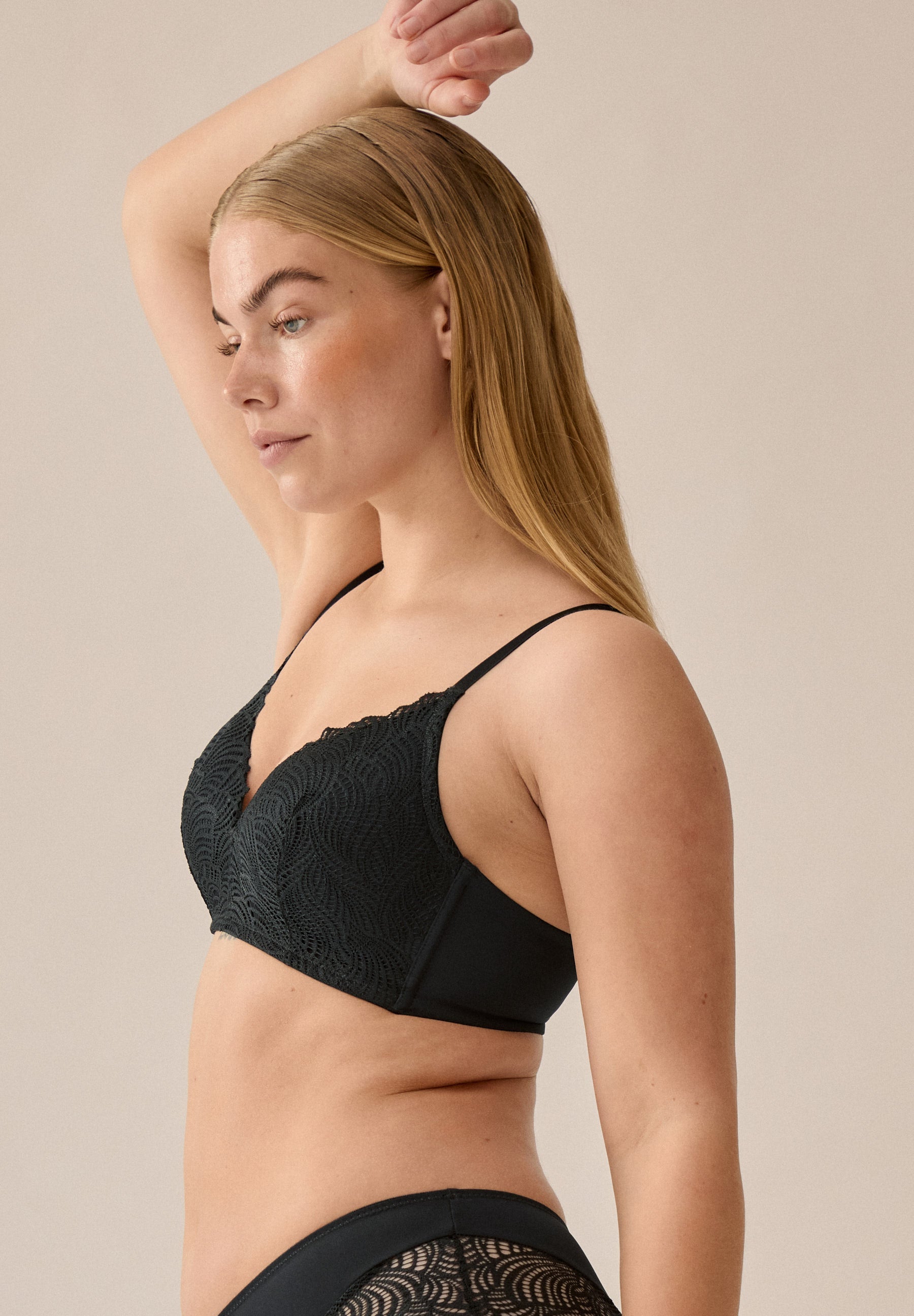 Zijde van vrouw die de voorgevormde soft bh met kant in de kleur zwart van het merk Naturana draagt
