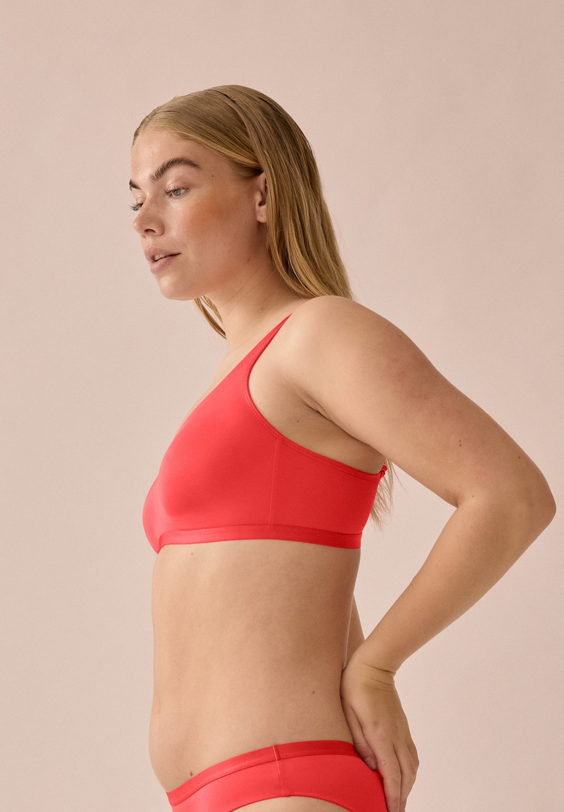 Zijde van vrouw die de minimizer bh in de kleur chayenne van het merk Naturana draagt