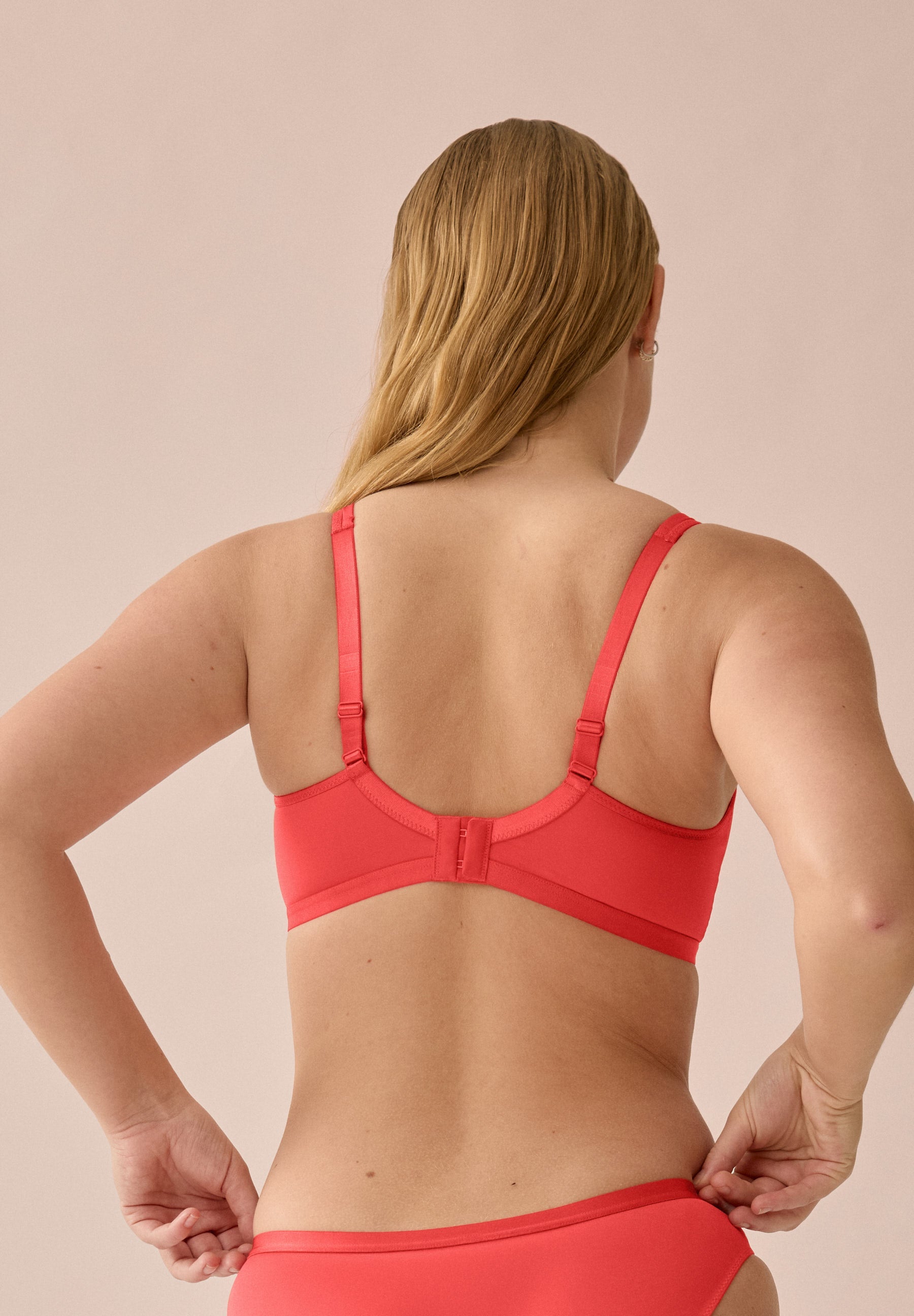 Achterzijde van vrouw die de minimizer bh in de kleur chayenne van het merk Naturana draagt