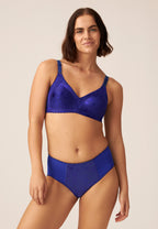 Voorzijde van vrouw die de minimizer bh met bloemenpatroon in de kleur galaxy violet van het merk Naturana draagt