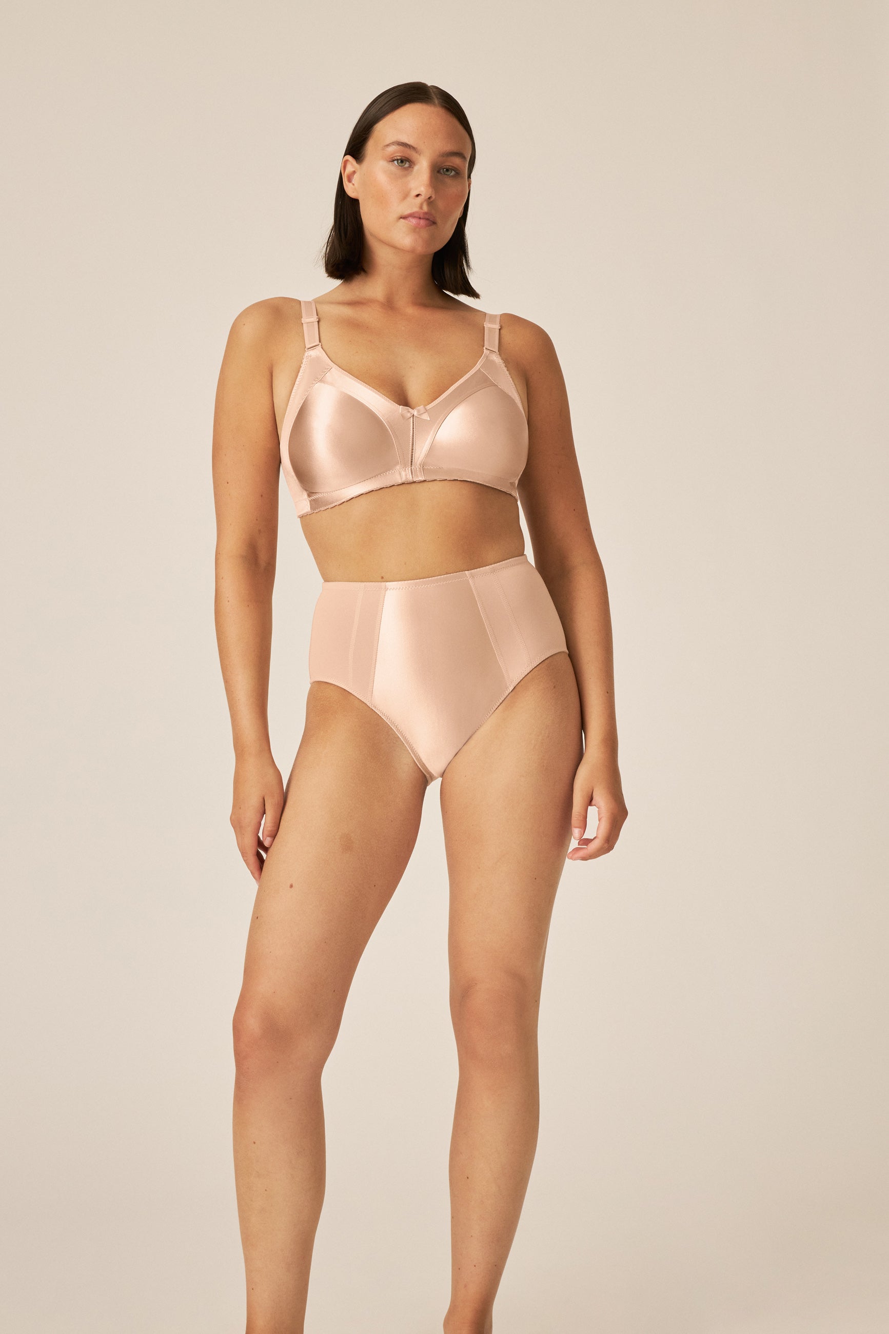 Voorzijde van vrouw die de minimizer bh met glanzend patroon in de kleur Beige van het merk Naturana draagt