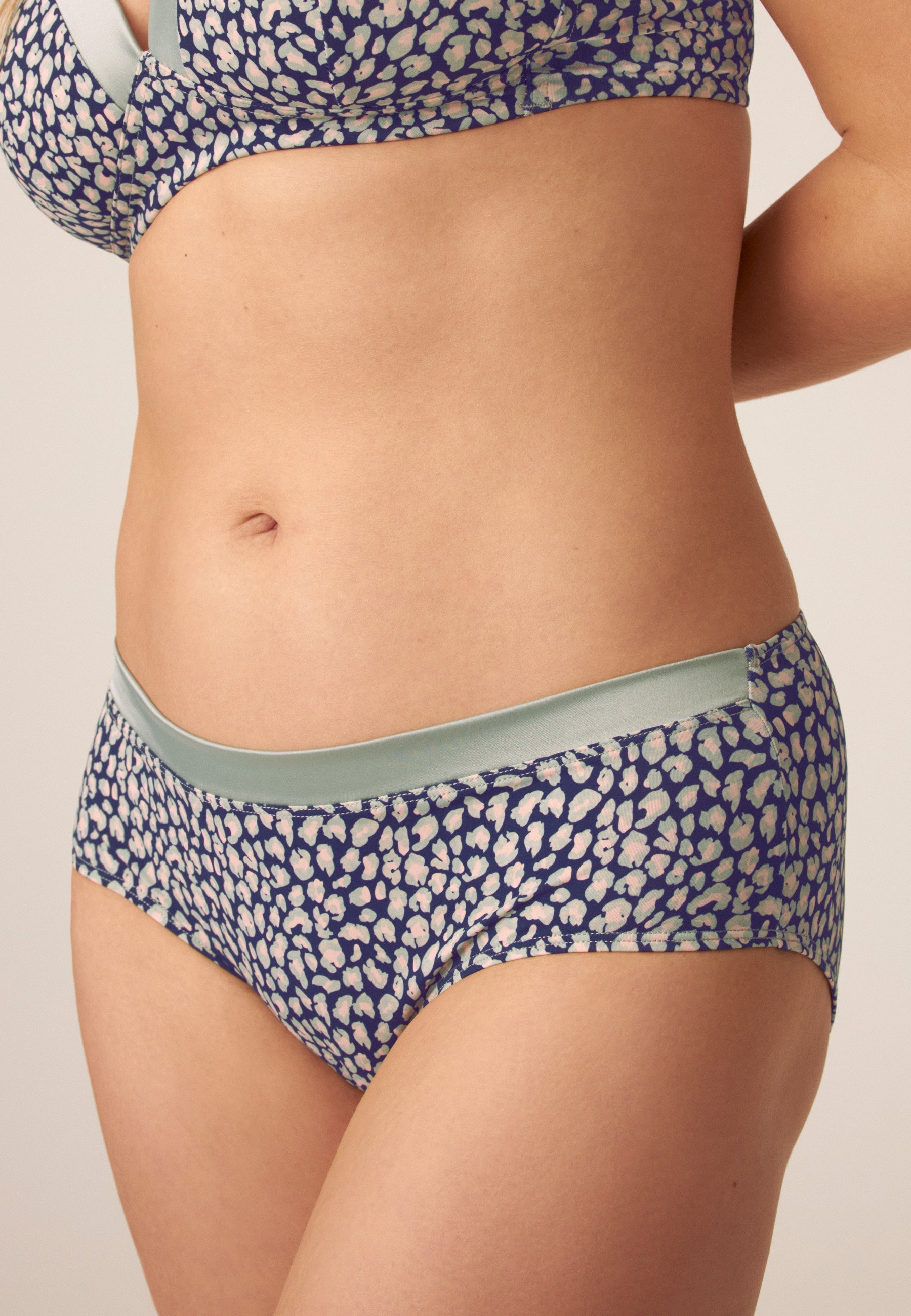 Voorzijde van vrouw die de soft bh met glansband en slip met glansband in de kleur leopard print van het merk Naturana draagt