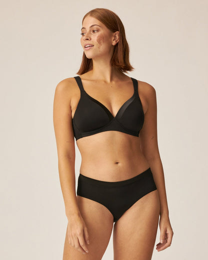 Voorzijde van vrouw die de soft bh met glansband en slip met glansband in de kleur zwart van het merk Naturana draagt
