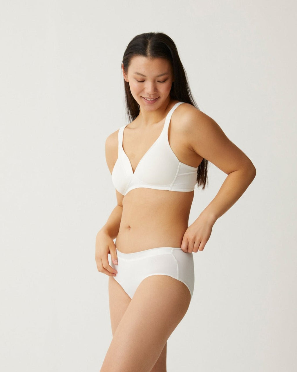 Zijde van vrouw die de soft bh met glansband en slip met glansband in de kleur ecru van het merk Naturana draagt