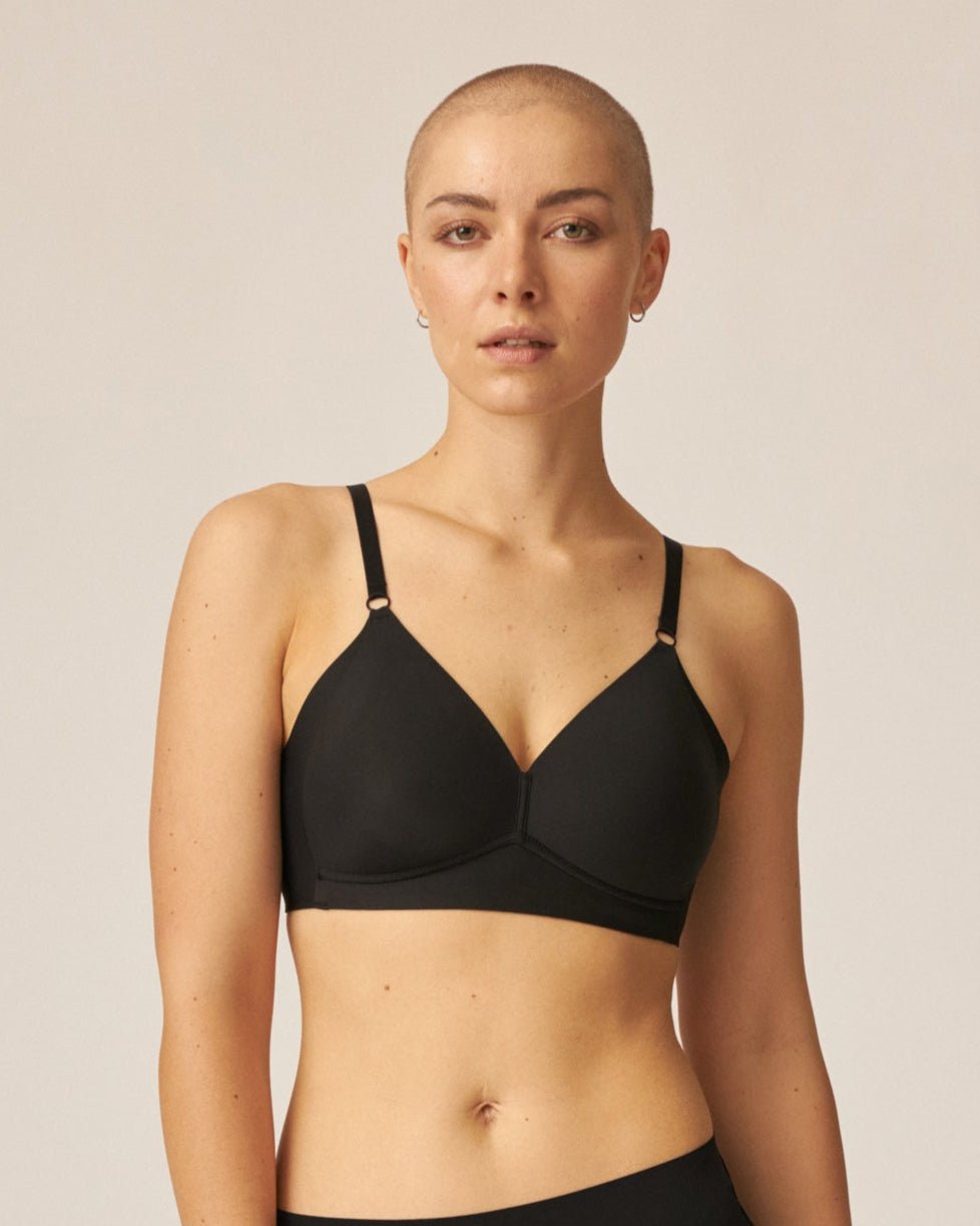 Voorzijde van vrouw die de side smoother bh zonder beugel in de kleur zwart van het merk Naturana draagt