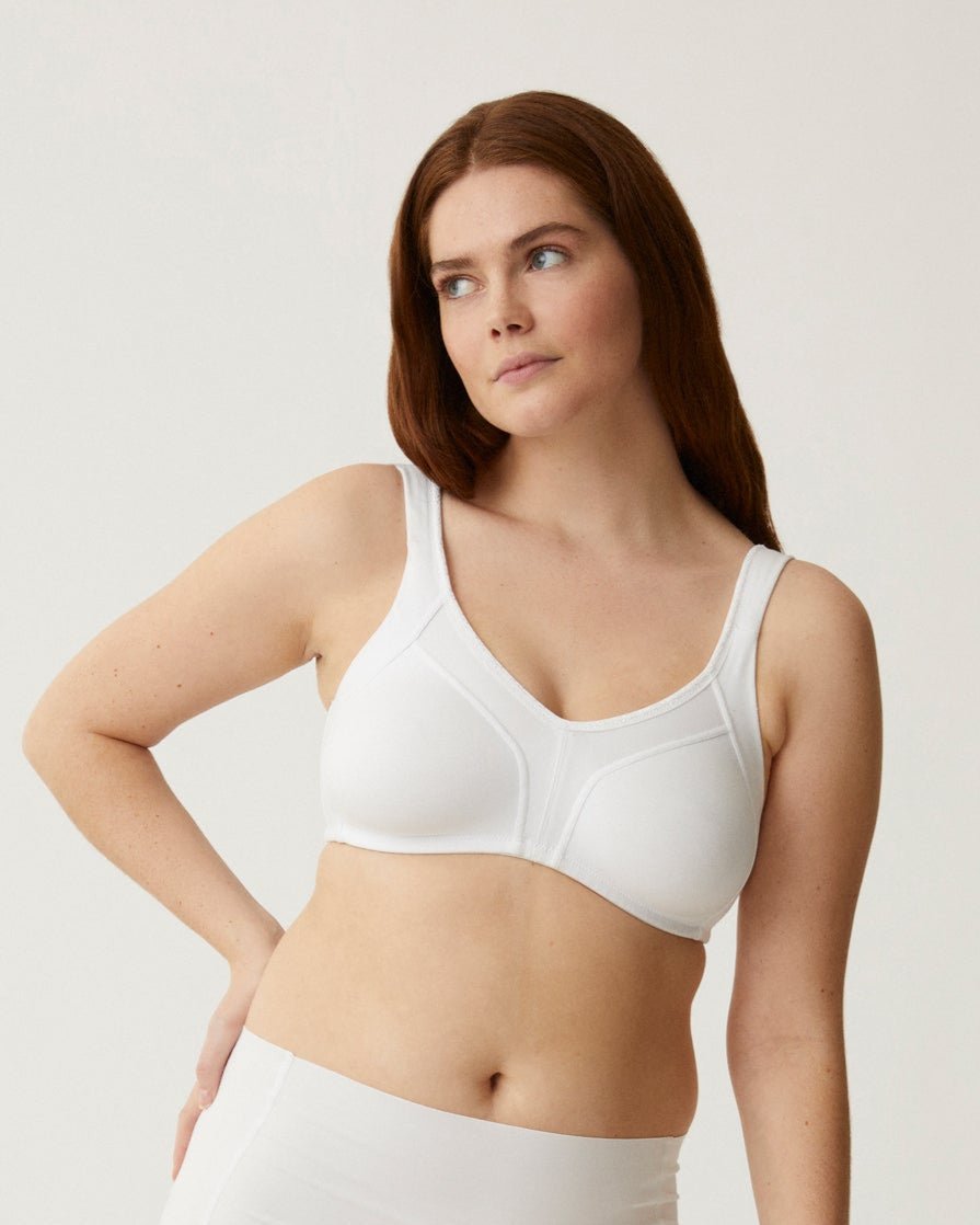 Voorzijde van vrouw die de minimizer bh met side smoother in de kleur wit van het merk Naturana draagt